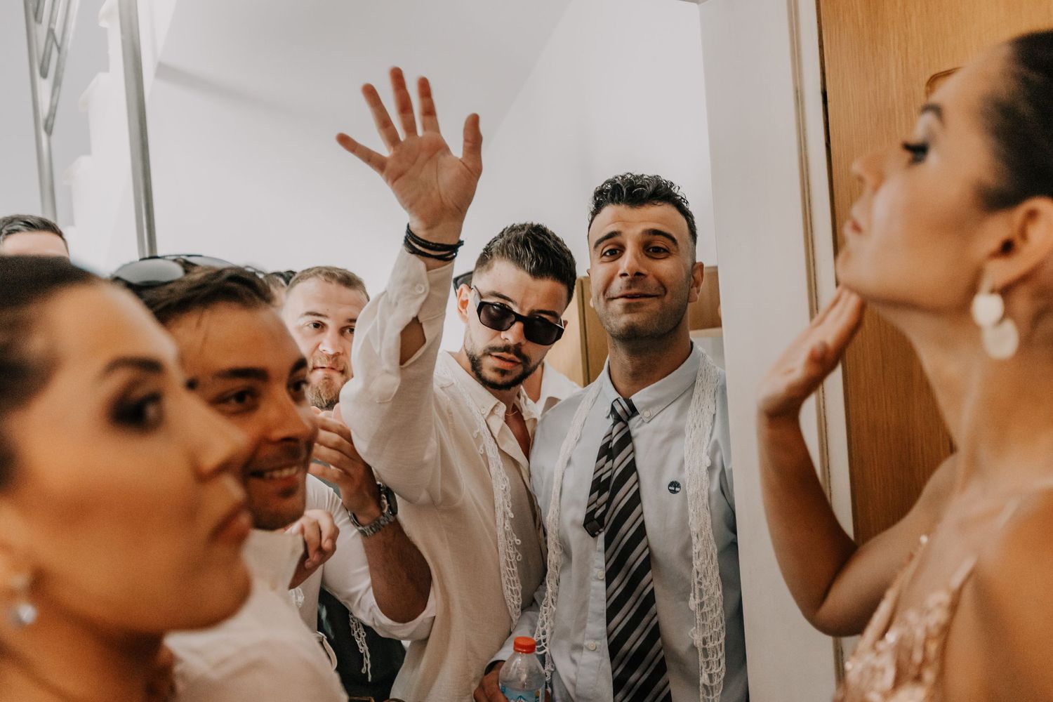 Wedding party members laughing and celebrating in formal attire.