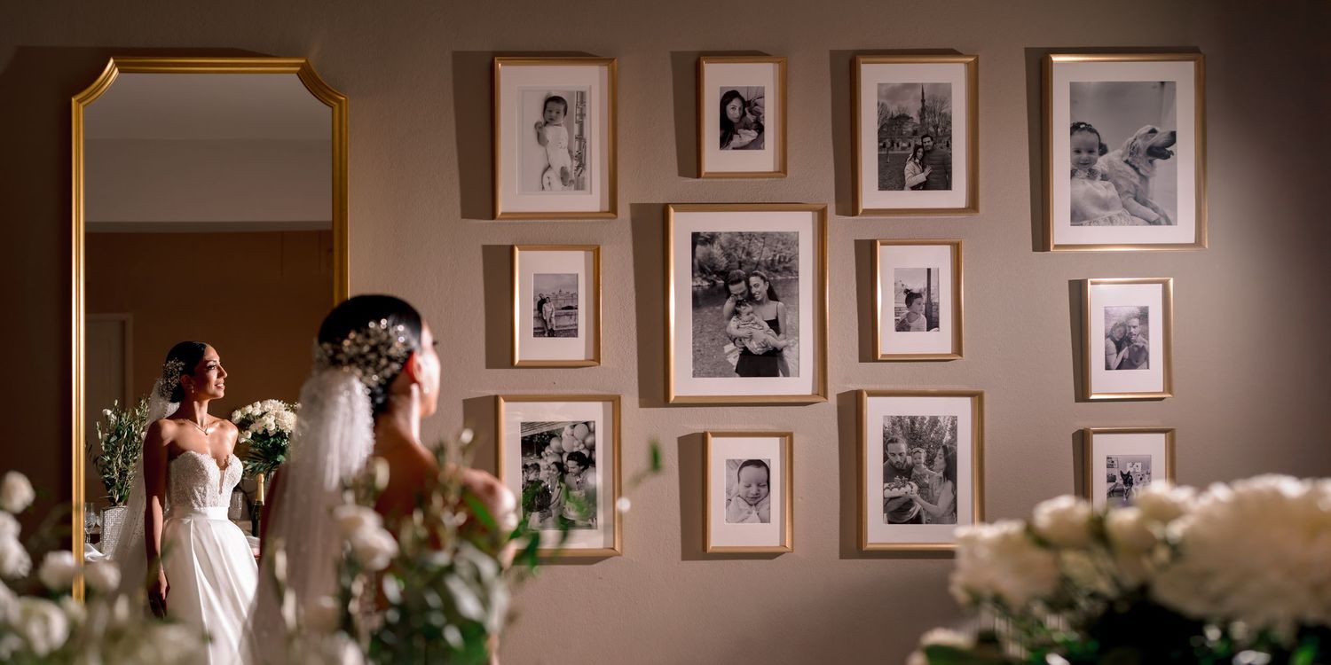 Wedding venue wall decorated with vintage family photos in matching frames.
