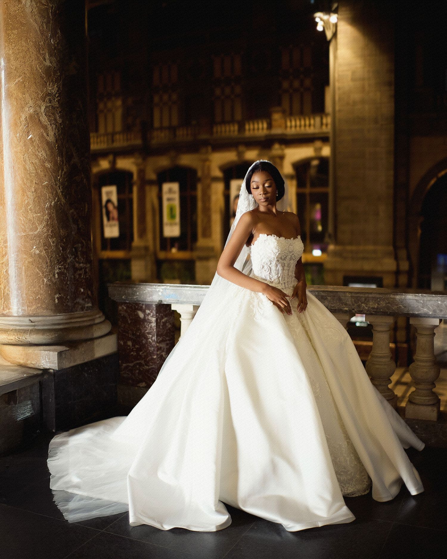 A stunning bridal portrait session featuring a voluminous white wedding gown in an ornate columned space.