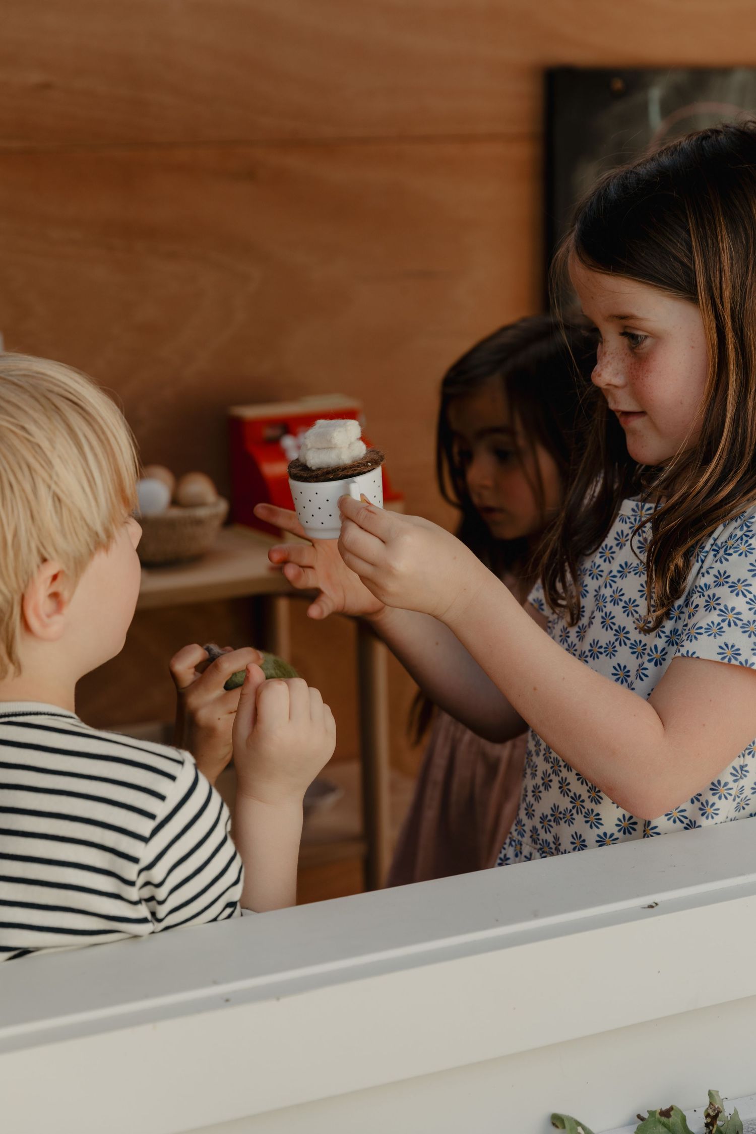 People enjoying snacks at a wooden table in a cozy indoor setting.