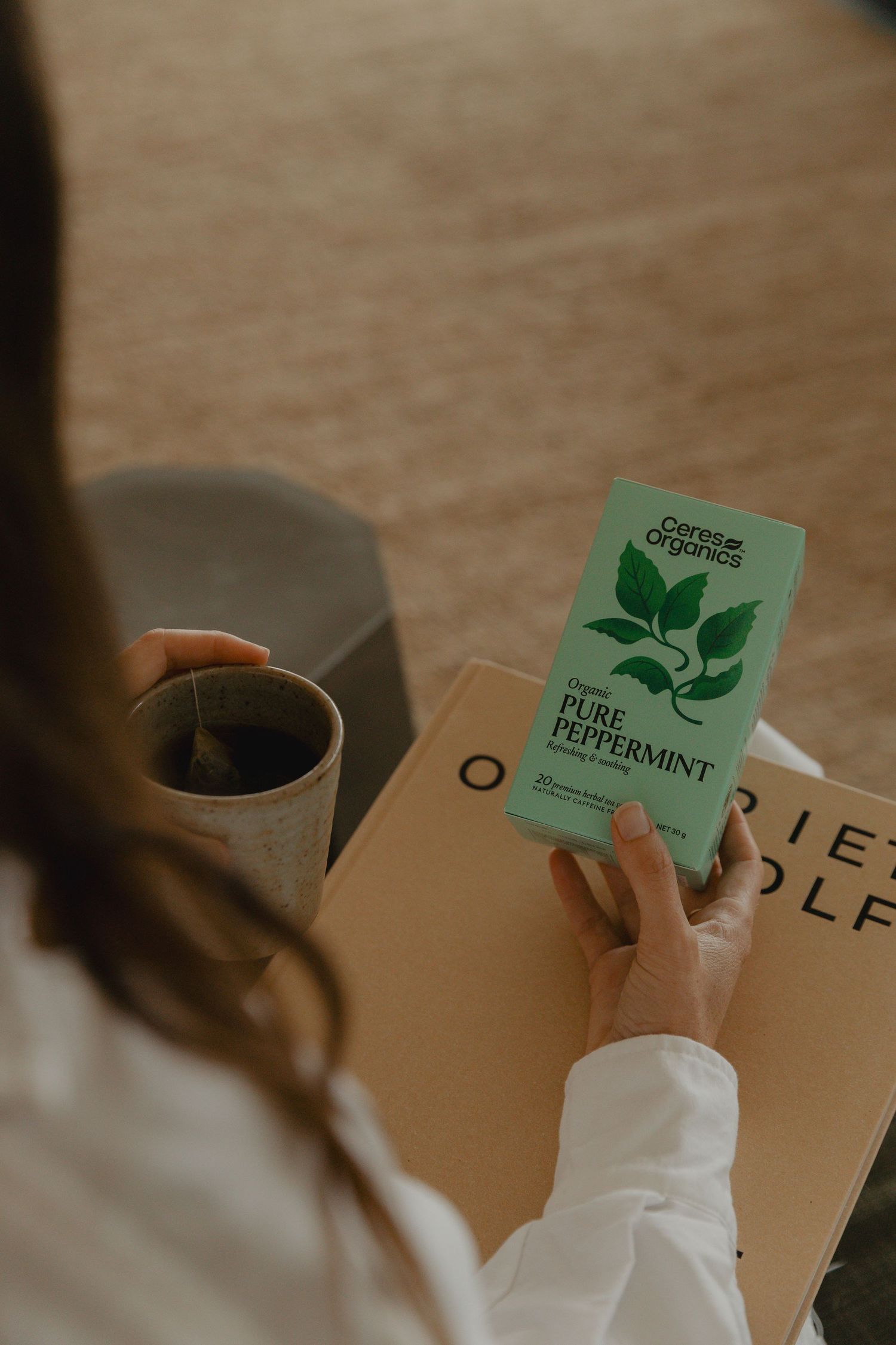 Tea boxes with green leaf designs displayed on a neutral background.