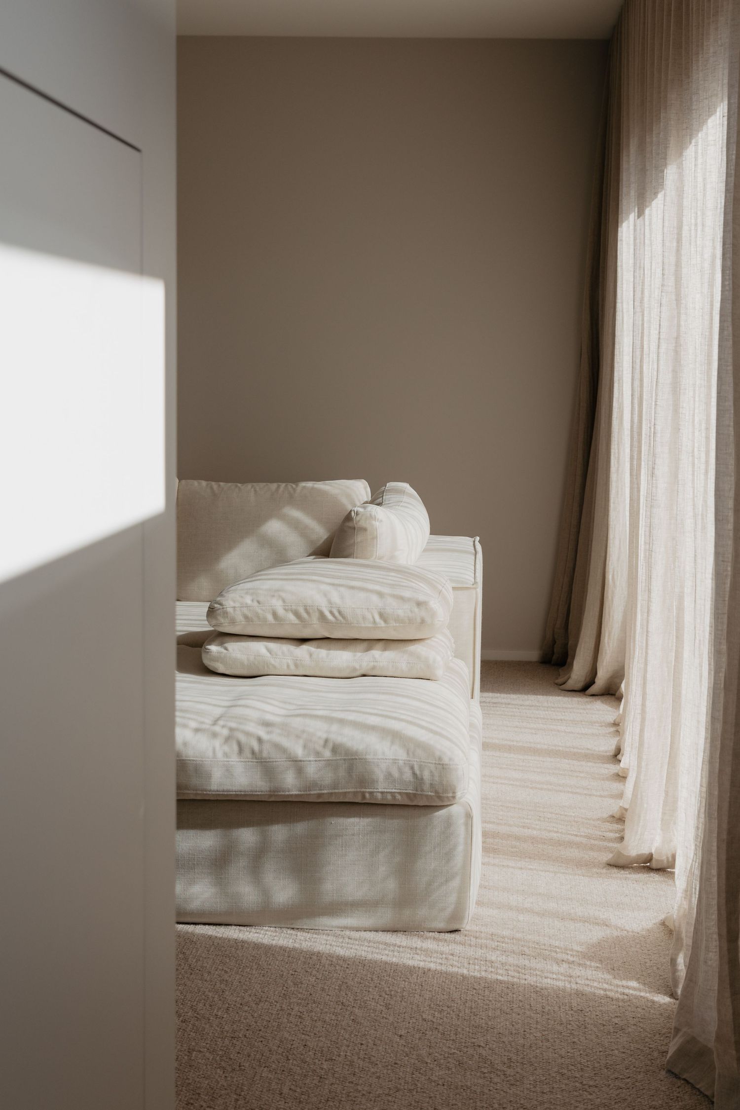 Light-filled room with white bedding and soft natural textures.