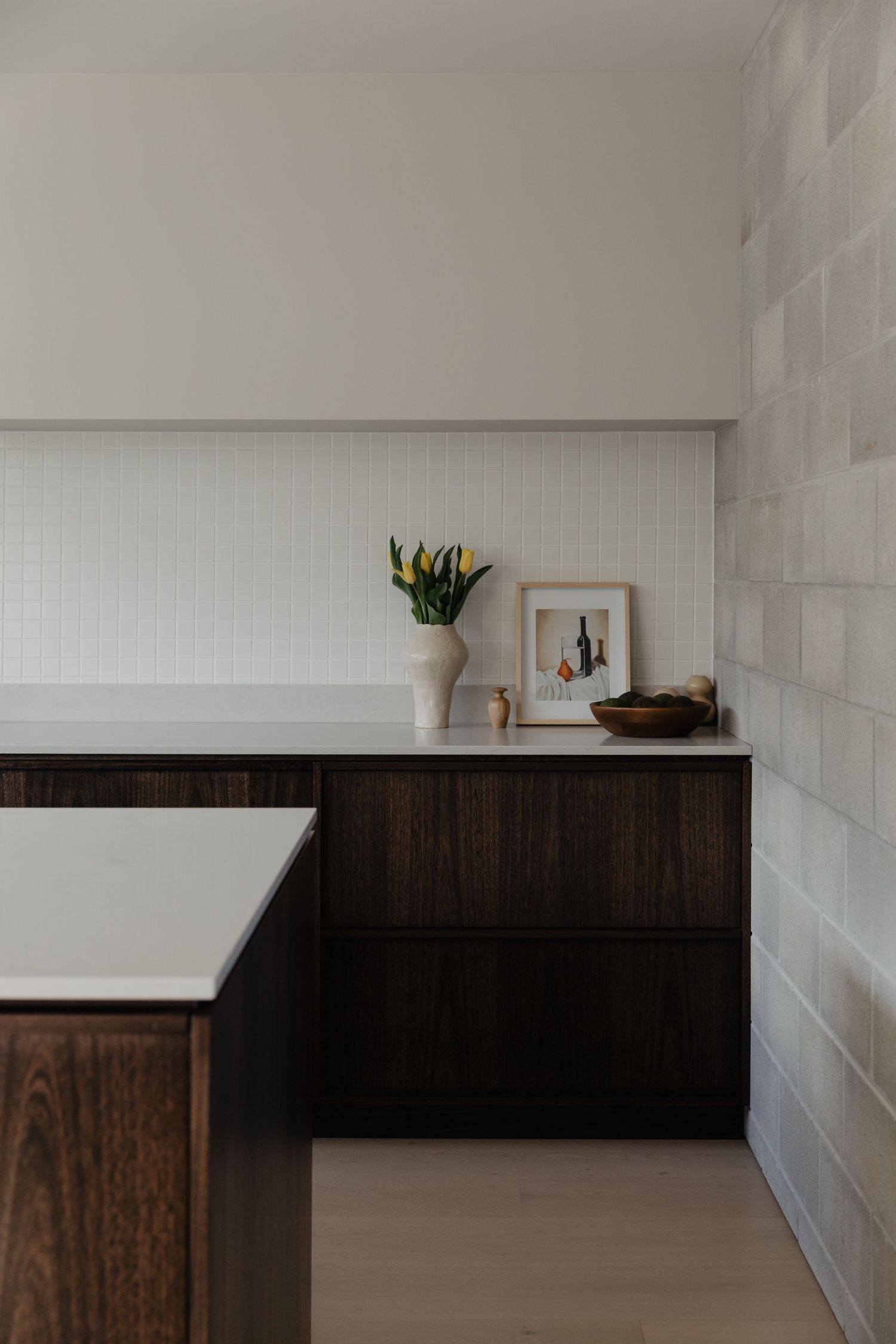 Modern interior with white walls, dark wood cabinetry, and minimal decor.
