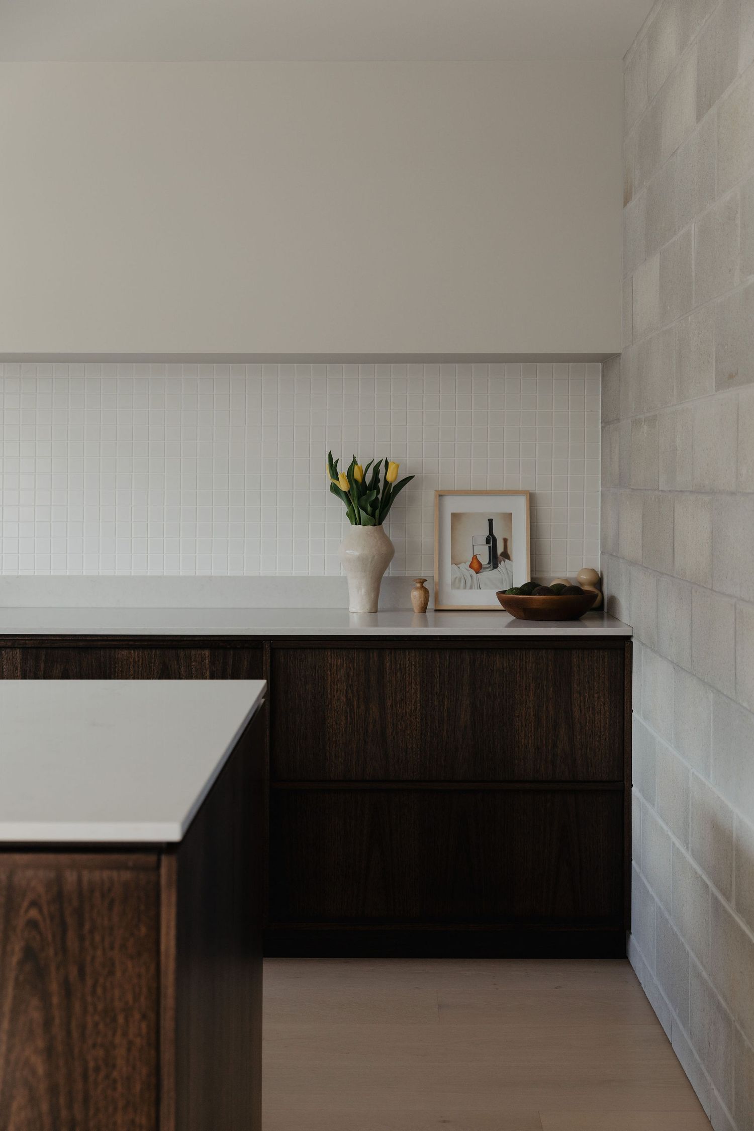 Modern interior with dark wood cabinets and white walls in minimalist style.