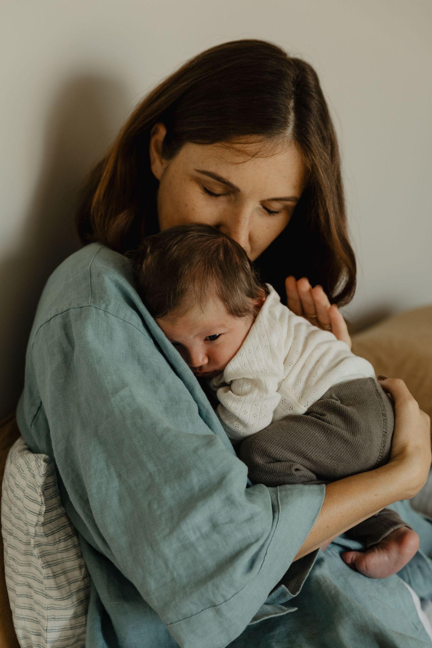 Tender embrace between parent and child in muted tones.