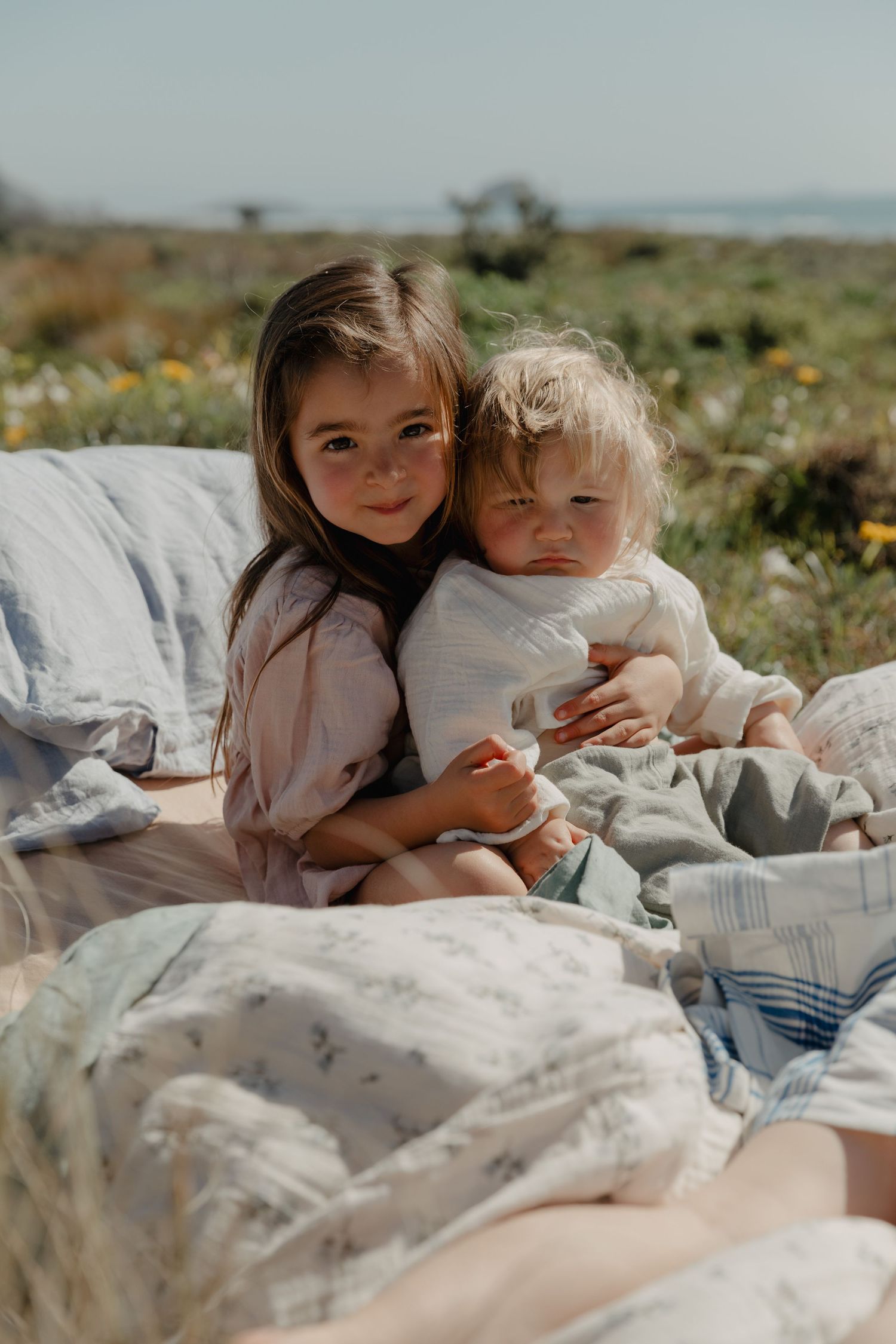 A cozy outdoor scene with blankets and cushions set up for relaxation.