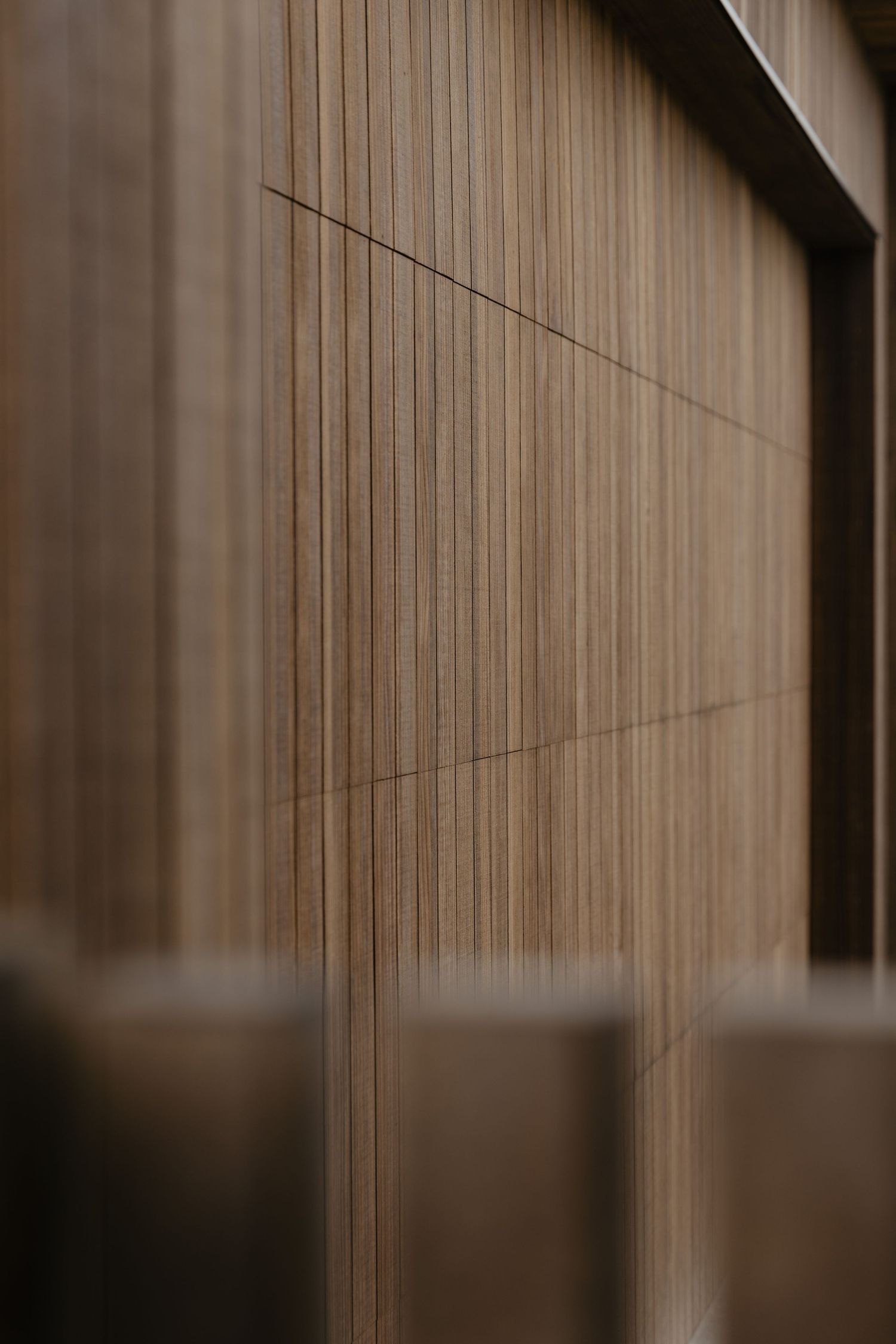 Detailed view of vertical wooden slat paneling in warm brown tones.