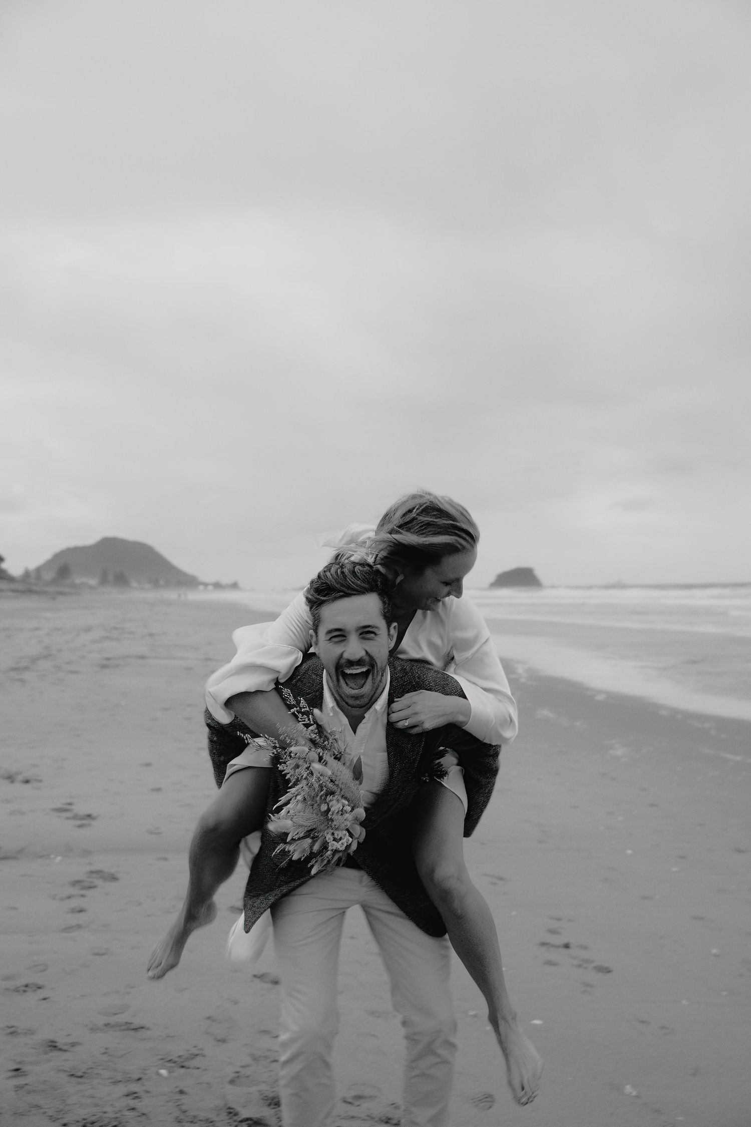 Playful moment captured on a beach with joyful expressions and movement.