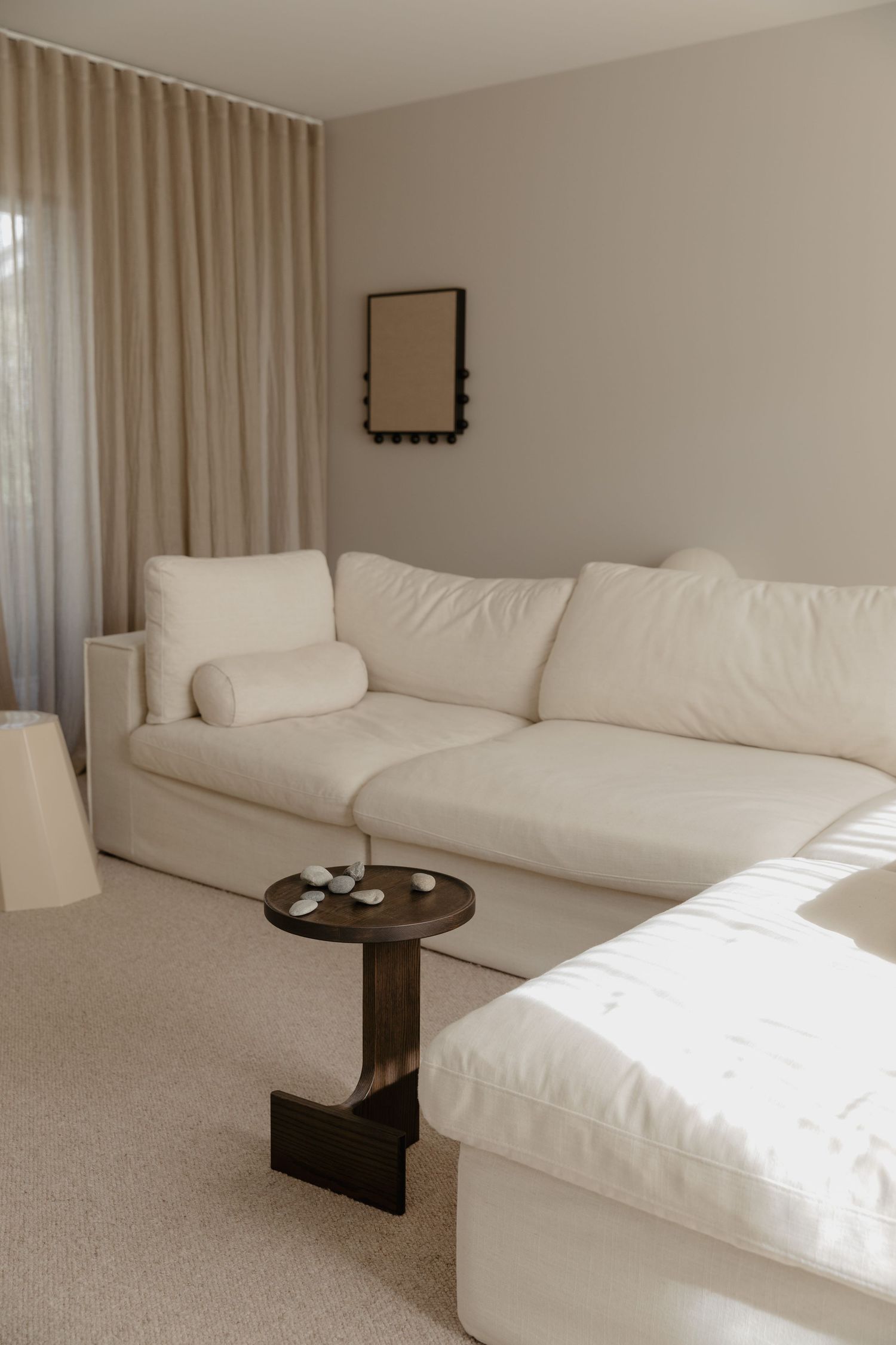 Contemporary living room with white sofa and dark wooden side table.