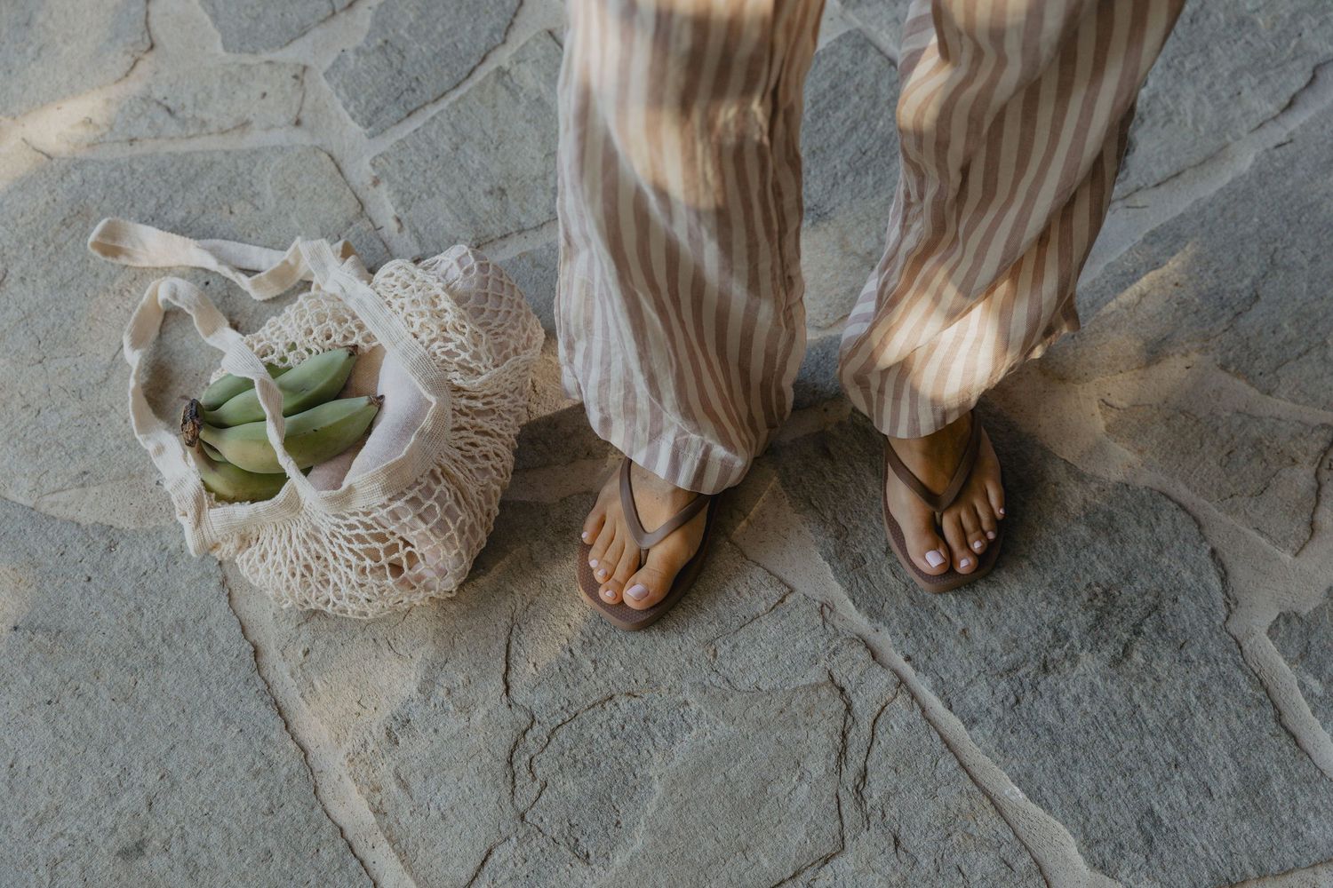 Bare feet walking on a stone path in natural lighting.