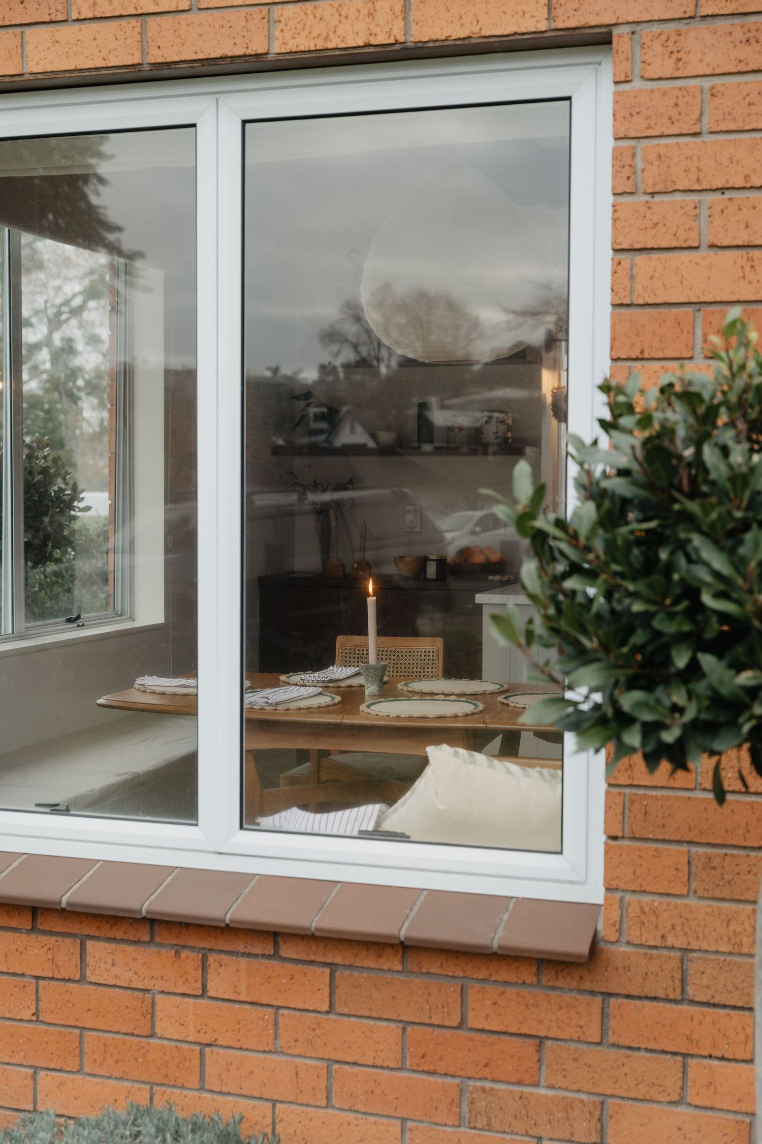 Modern windows with white frames set in orange brick exterior wall.