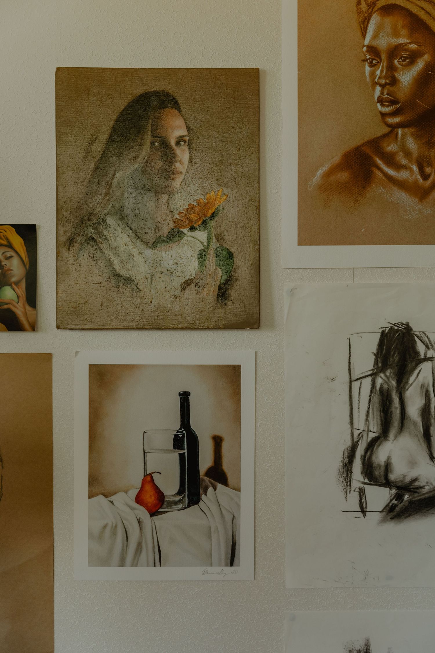 Gallery wall displaying various artistic portraits and still life photographs.