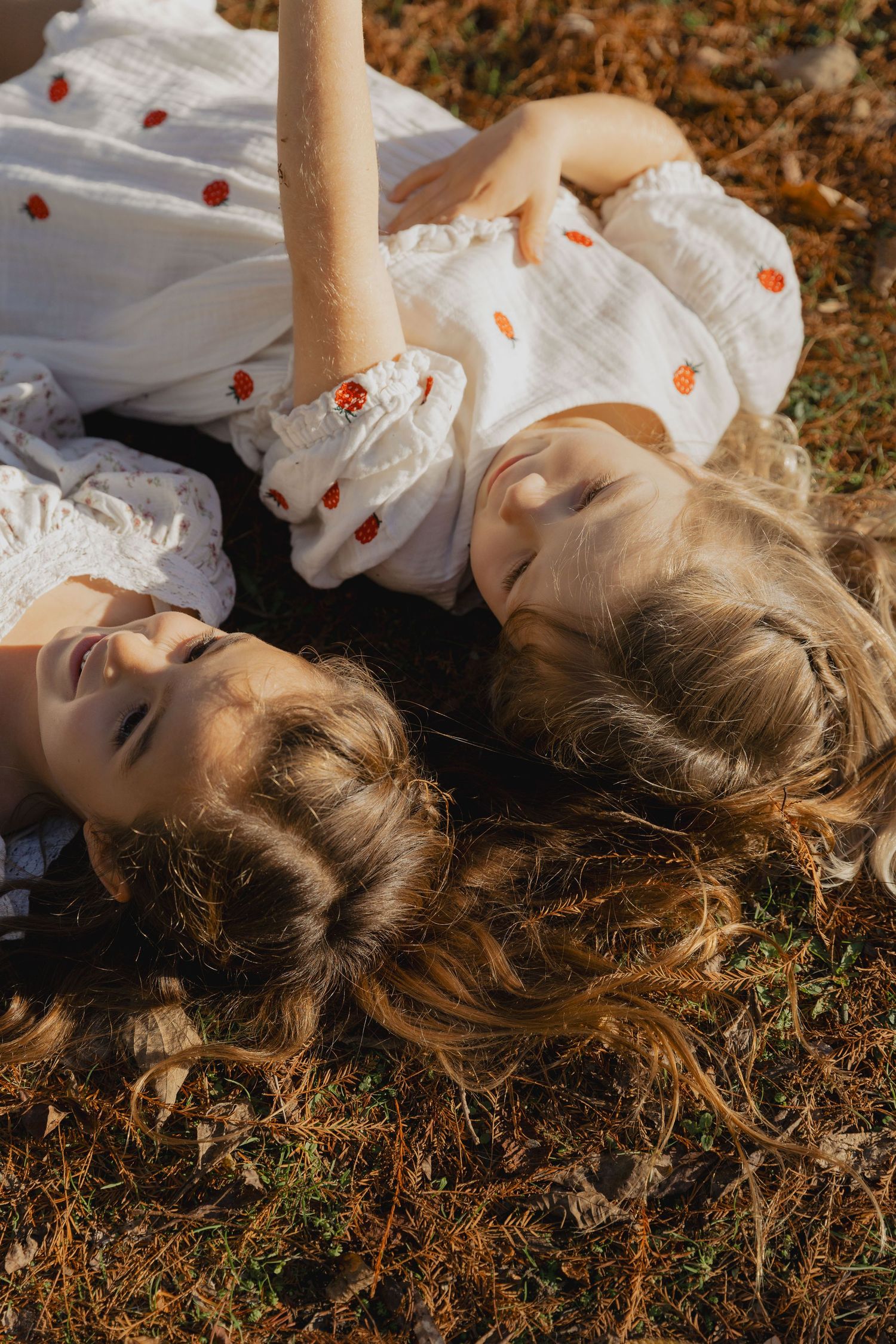 Person lying in grass wearing a white dress in autumn sunlight.