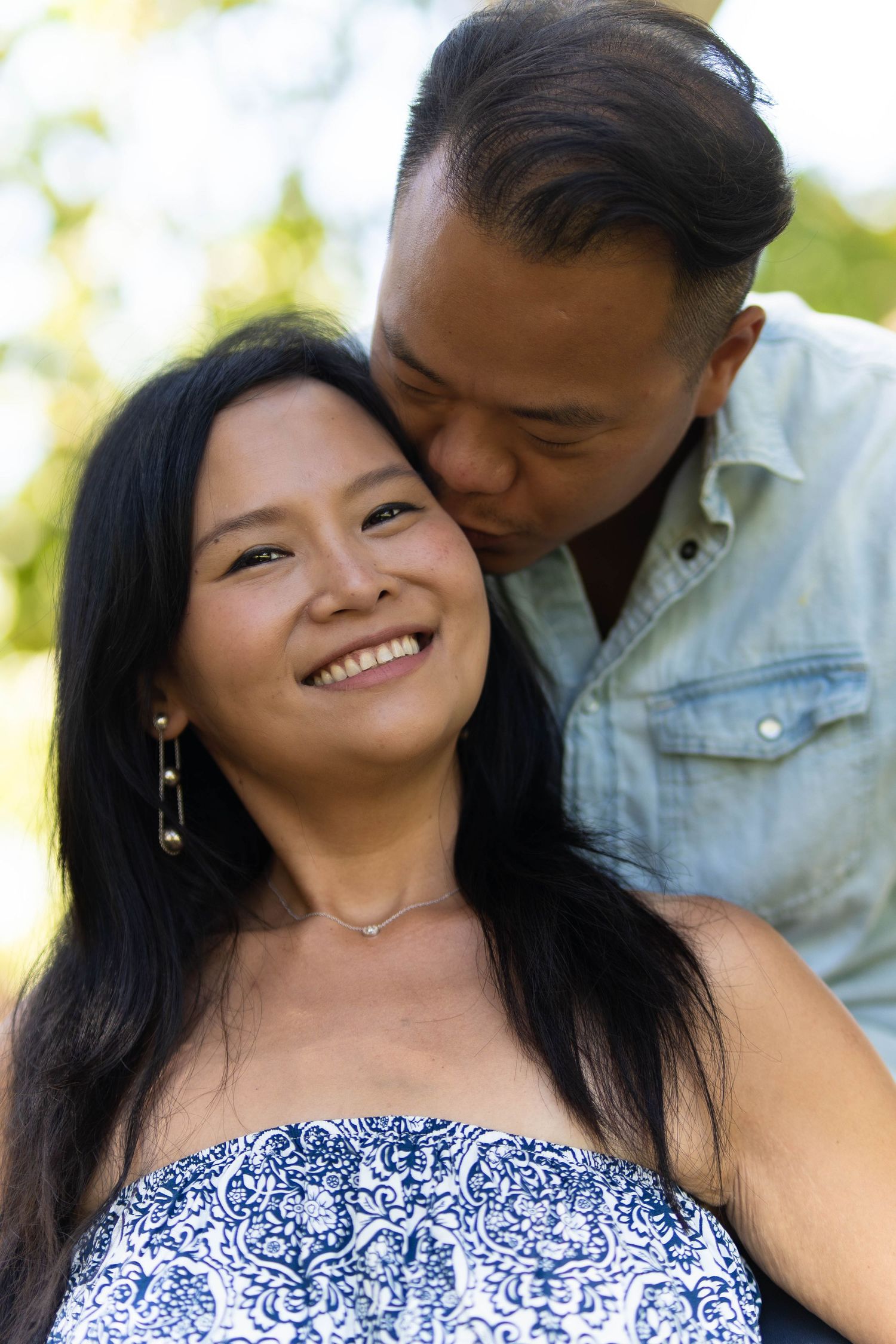 Couple sharing intimate moments against natural outdoor backdrop.