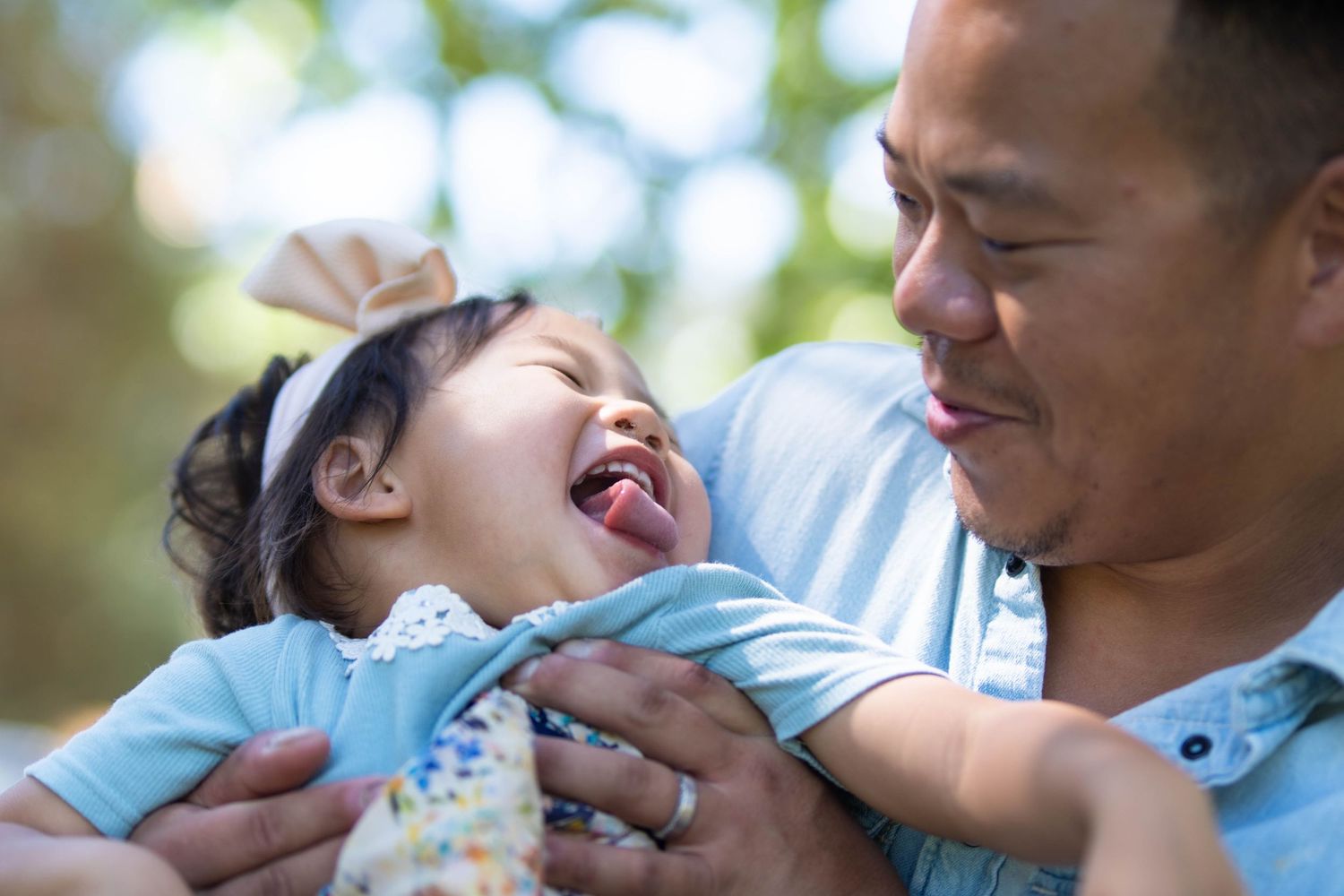 A heartwarming sequence of candid moments between a parent and child sharing laughter and affection outdoors.