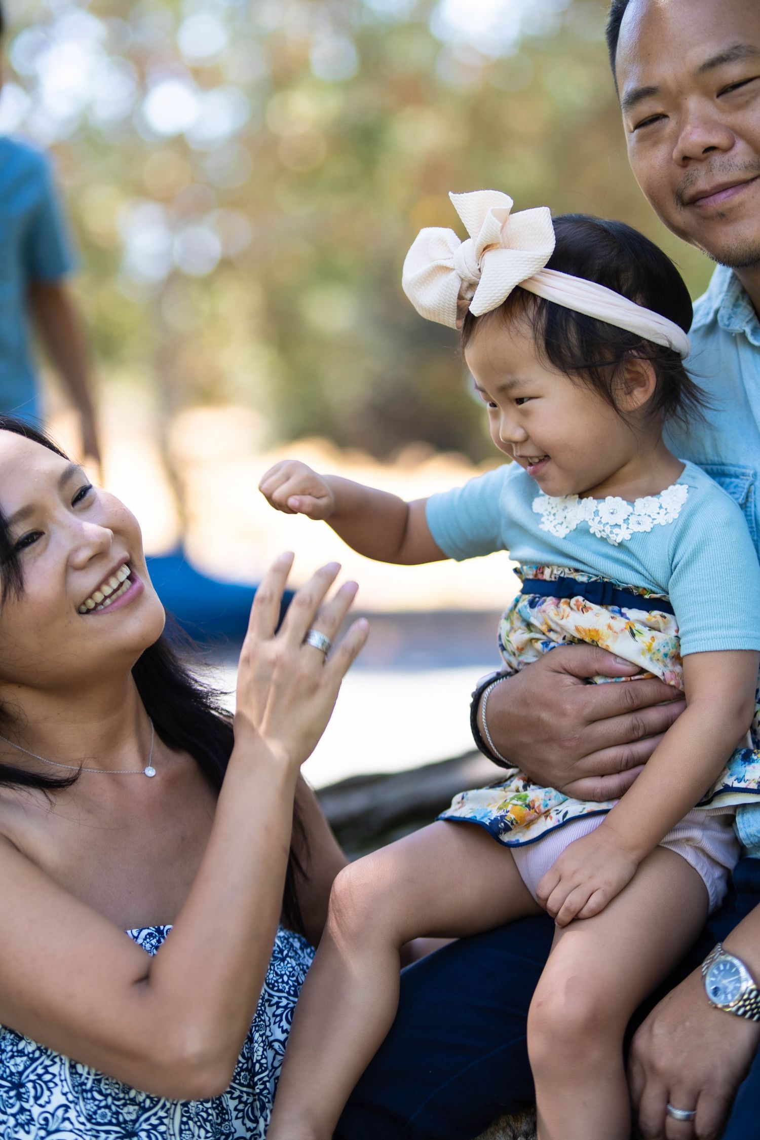 Family sharing intimate moments and laughter during an outdoor photo session.