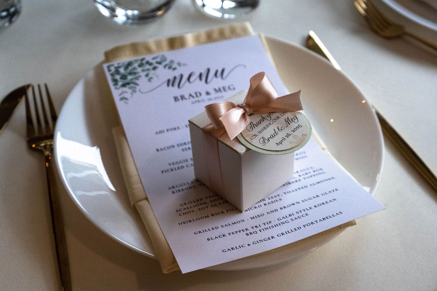 Wedding reception place settings with elegant menu cards and rose gold accents.