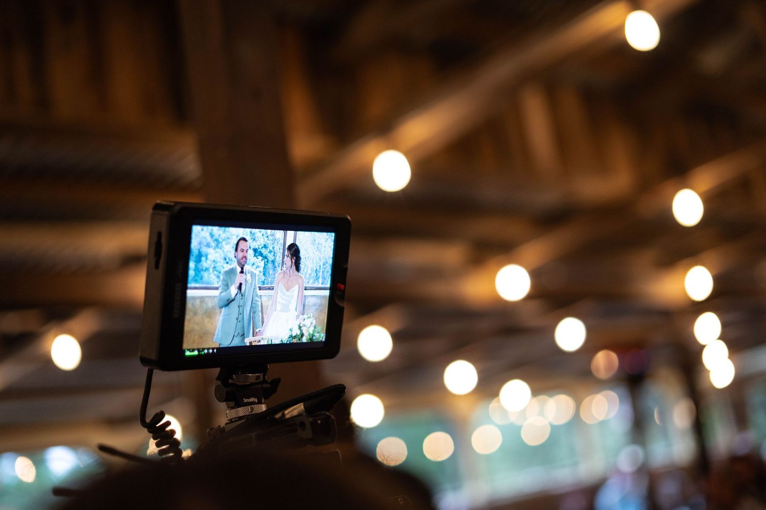 String lights create a warm ambiance in an indoor venue with exposed wooden beams.
