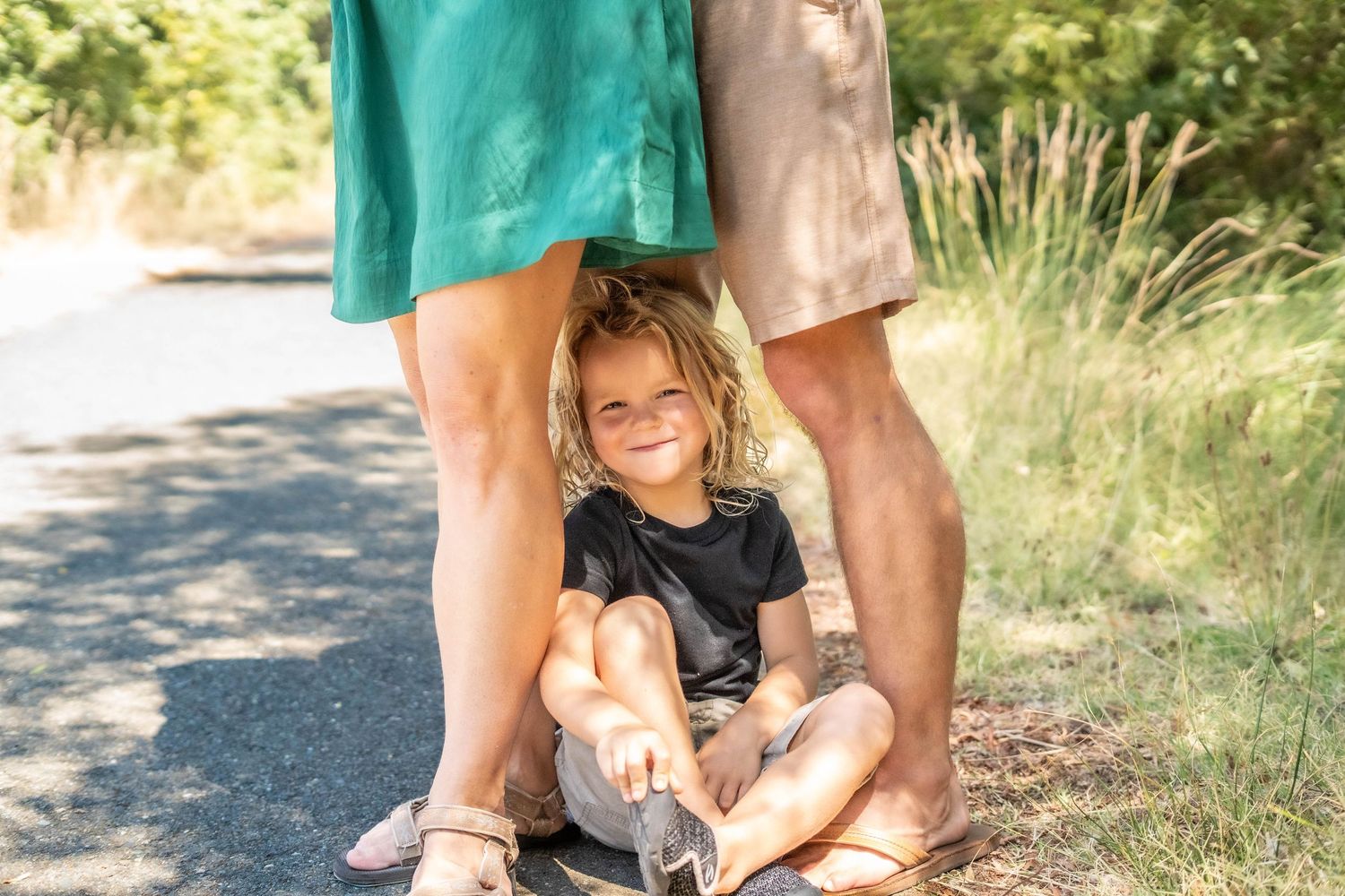 Candid family moments captured on a path surrounded by greenery.