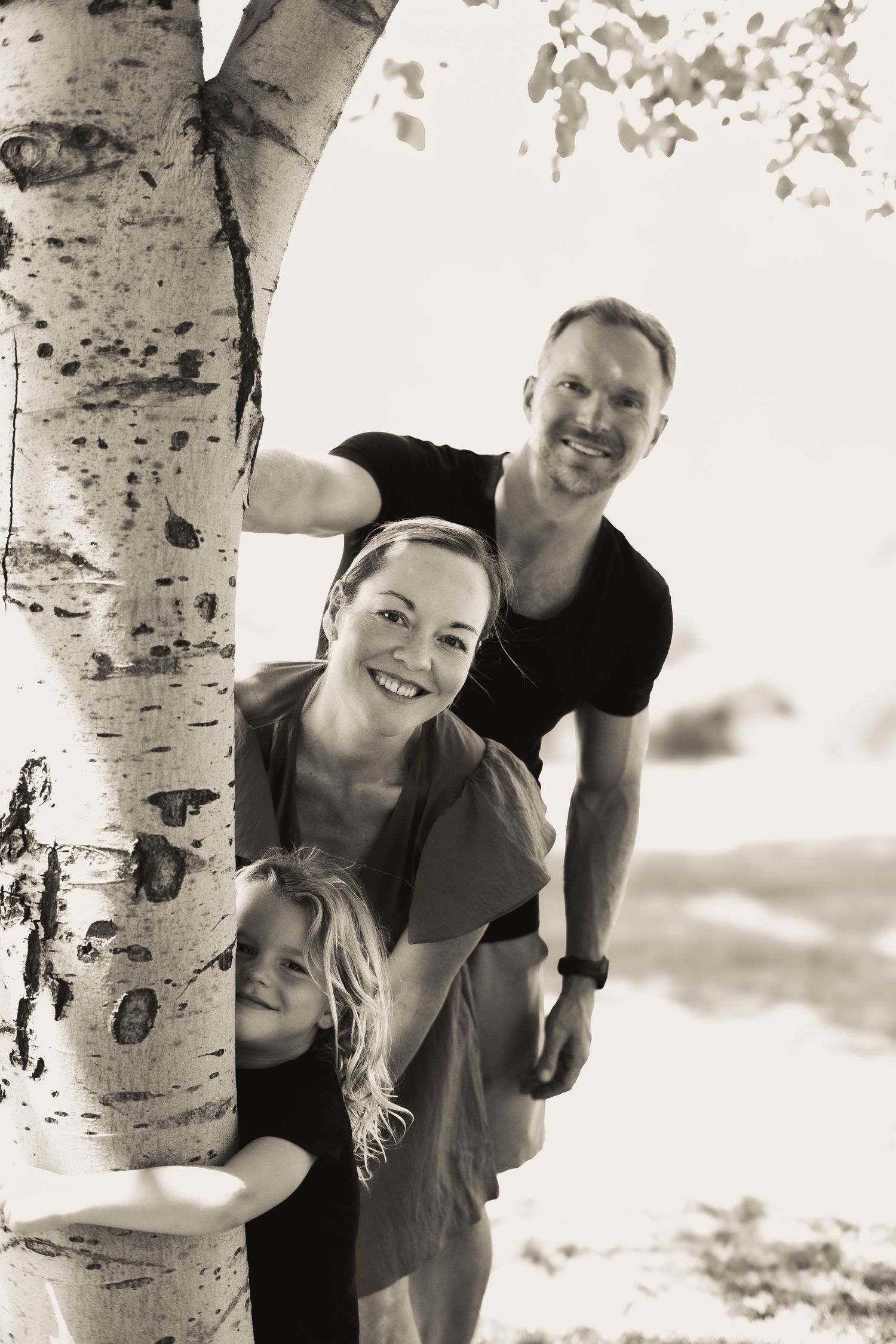 Black and white portraits showing affectionate moments near birch trees.