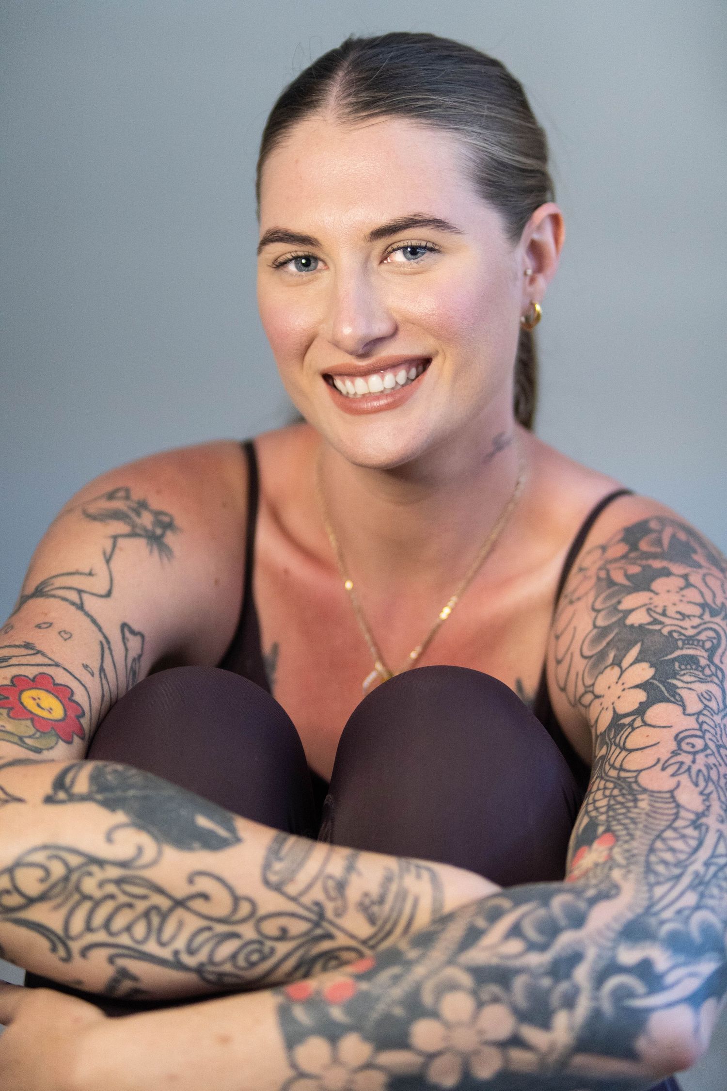 Portrait series showing intricate floral and artistic tattoo designs against a grey background.