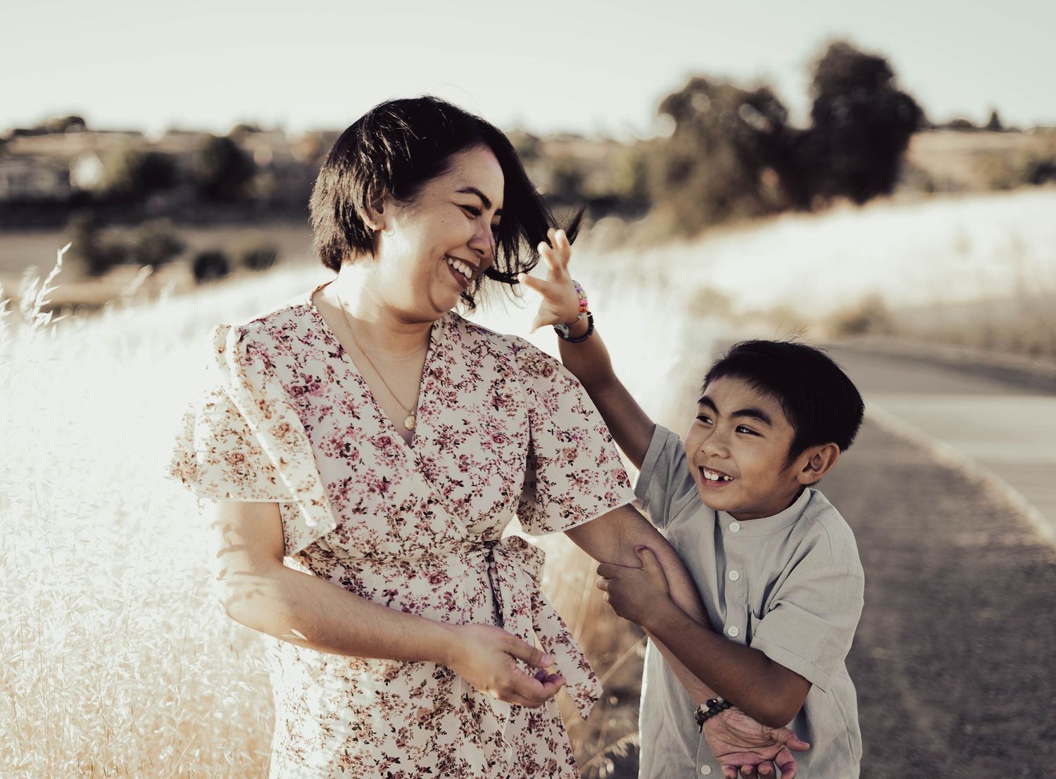 Sweet candid family moments captured in soft golden sunlight on a rural path.