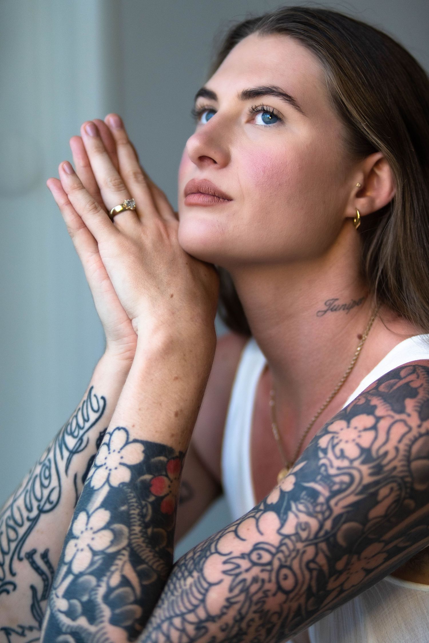 Close-up shots of floral tattoo sleeve and clasped hands in prayer pose.