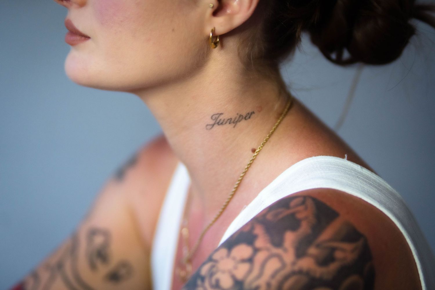 Side profile views showing detailed floral tattoo sleeve against blue background.