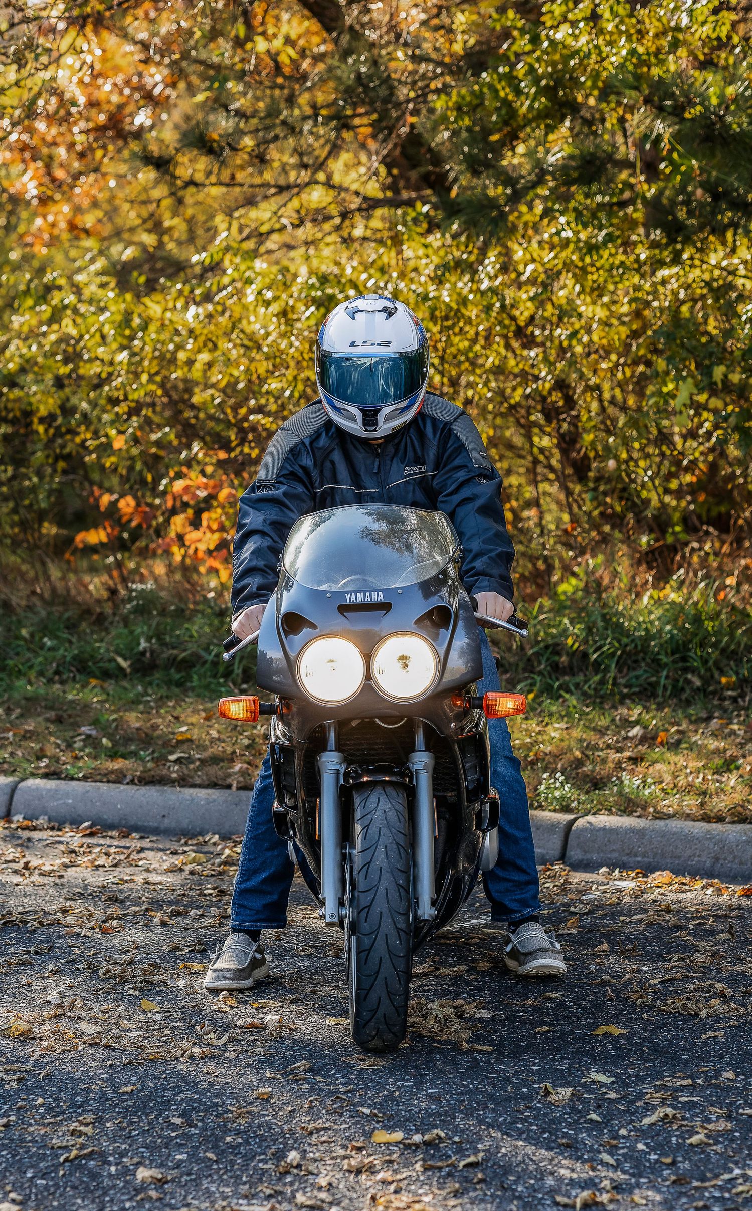 Front view of man sitting on motorcycle with white helmet on