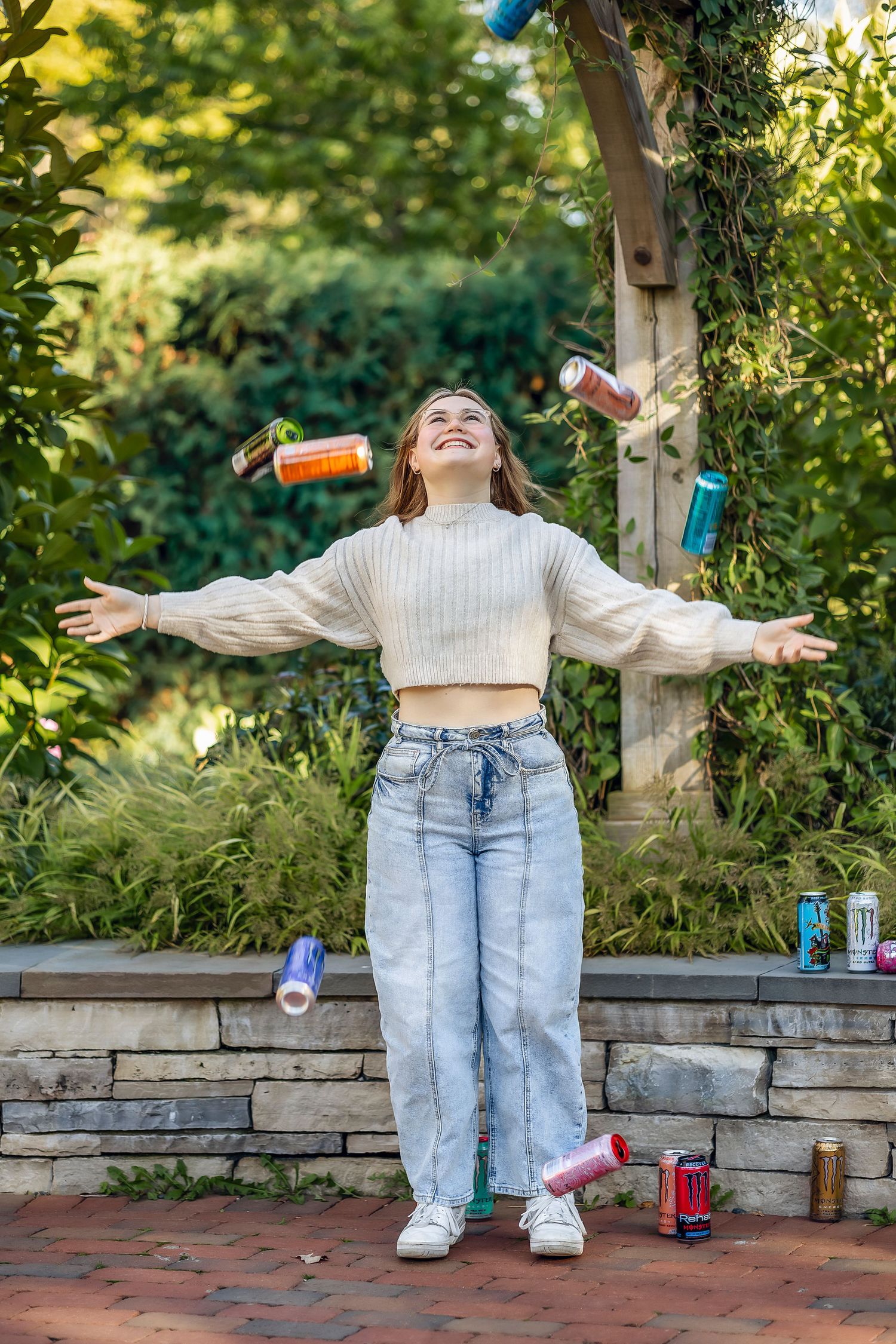 Girl smiling while throwing cans in the air