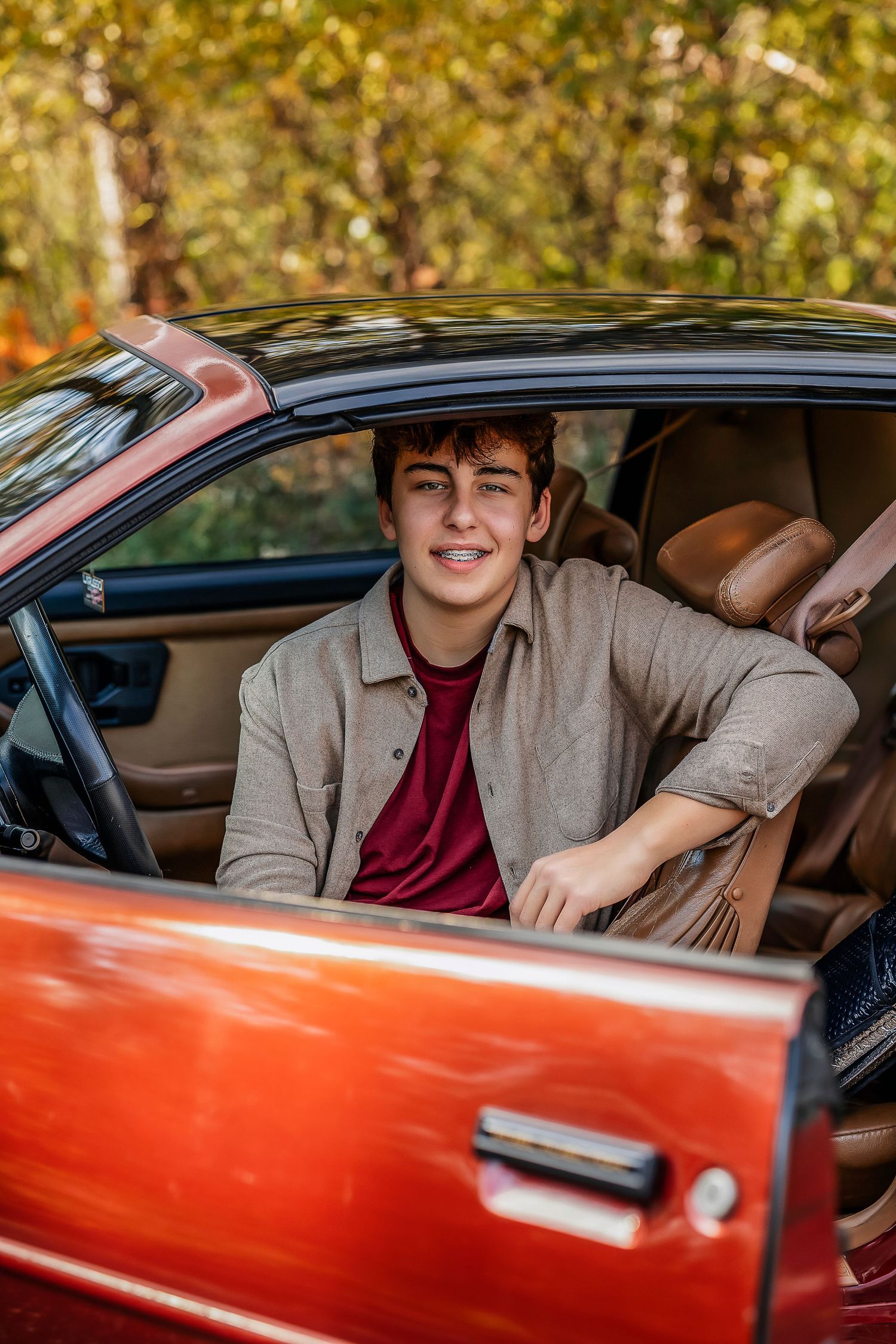 Boy sitting in a red car