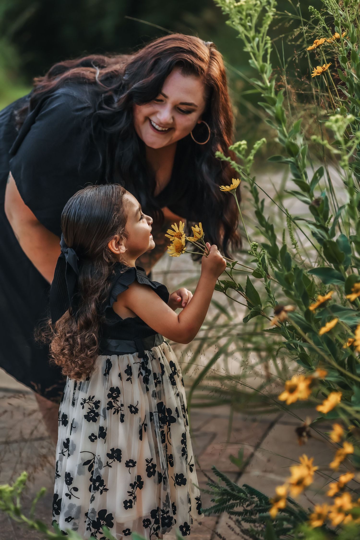 Mother and daughter stopping to smell the flowers