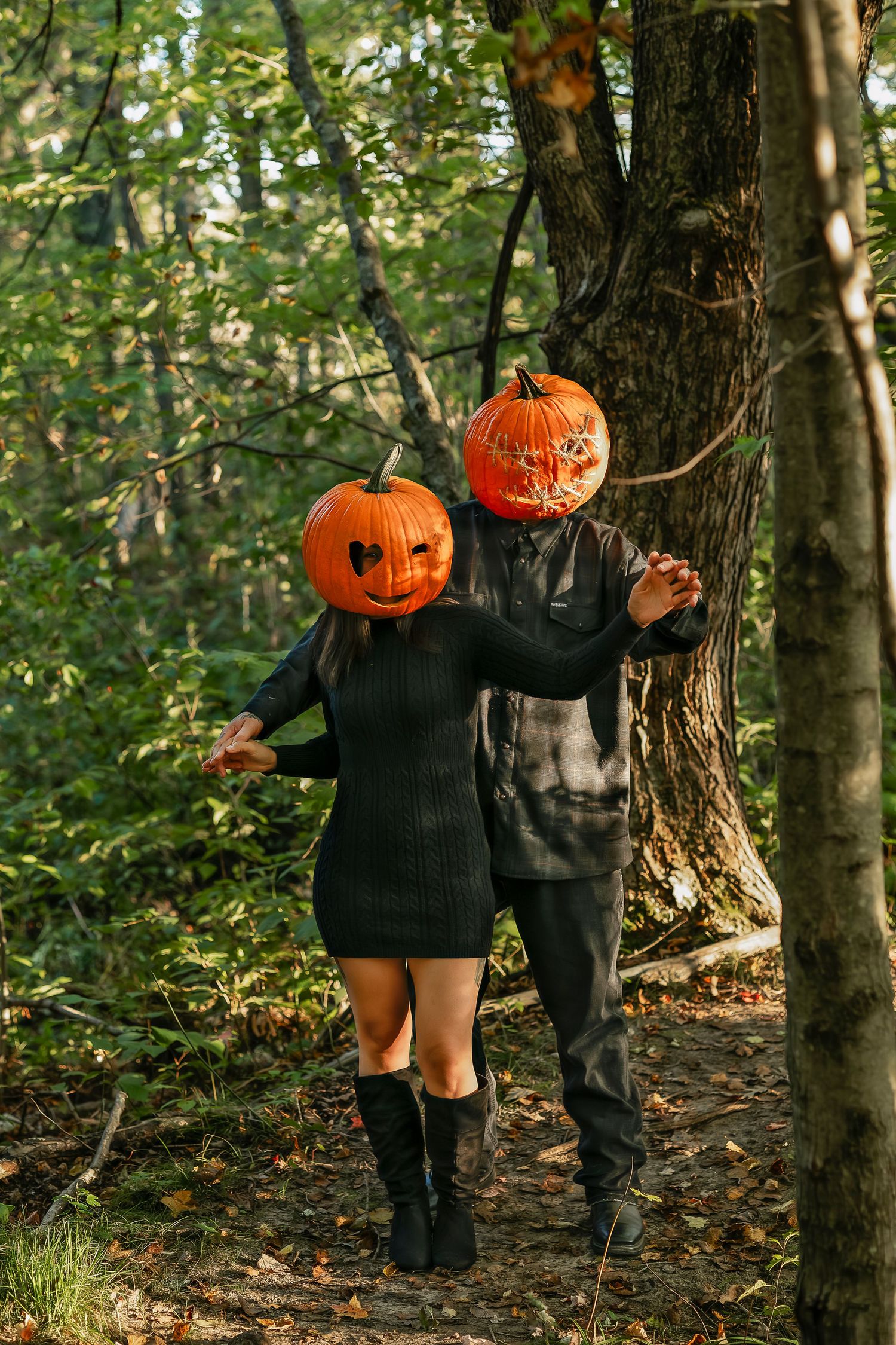 Pumpkin head couple dancing in the woods