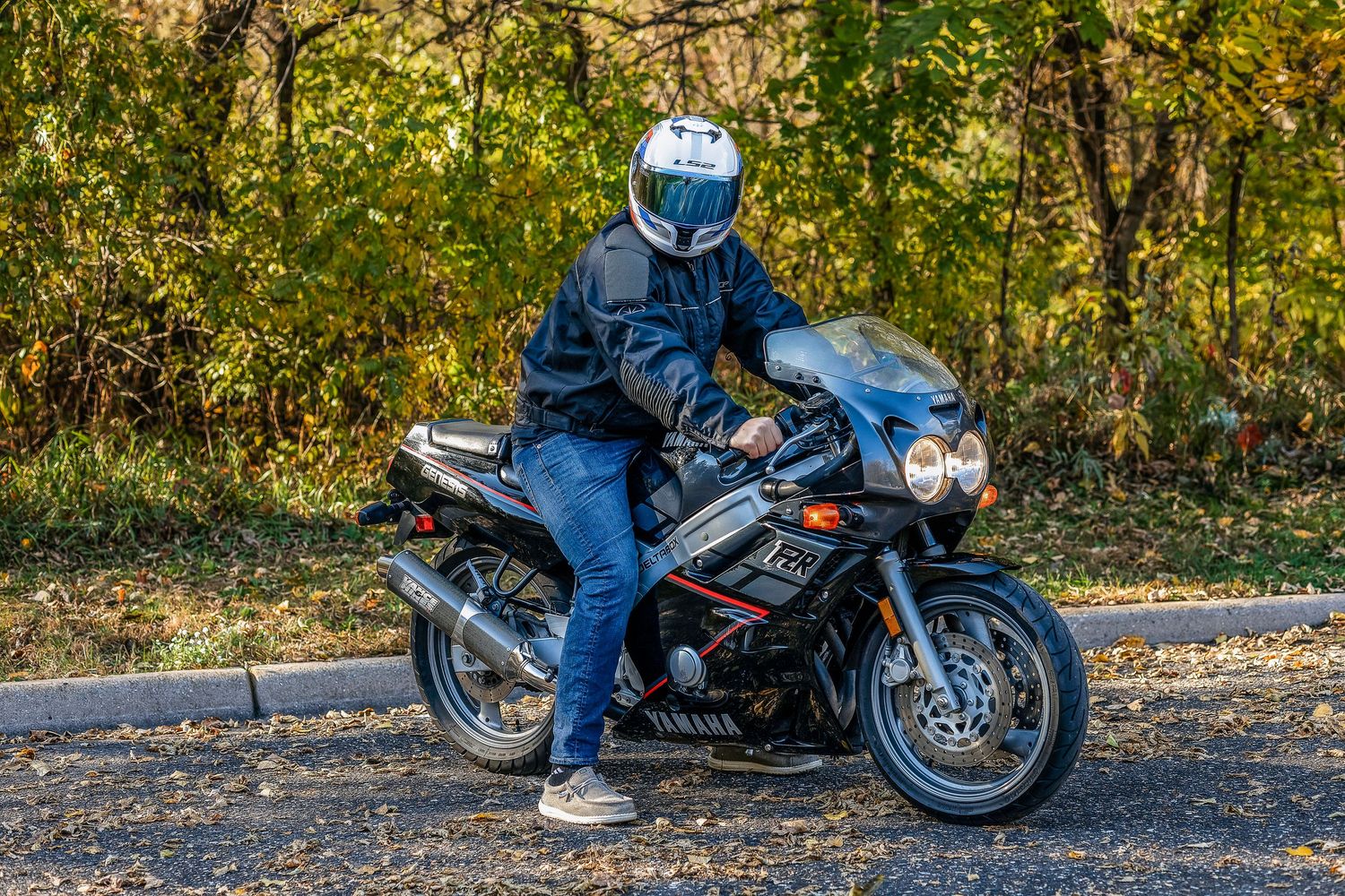 Man looking at camera wearing a white helmet on a motorcycle