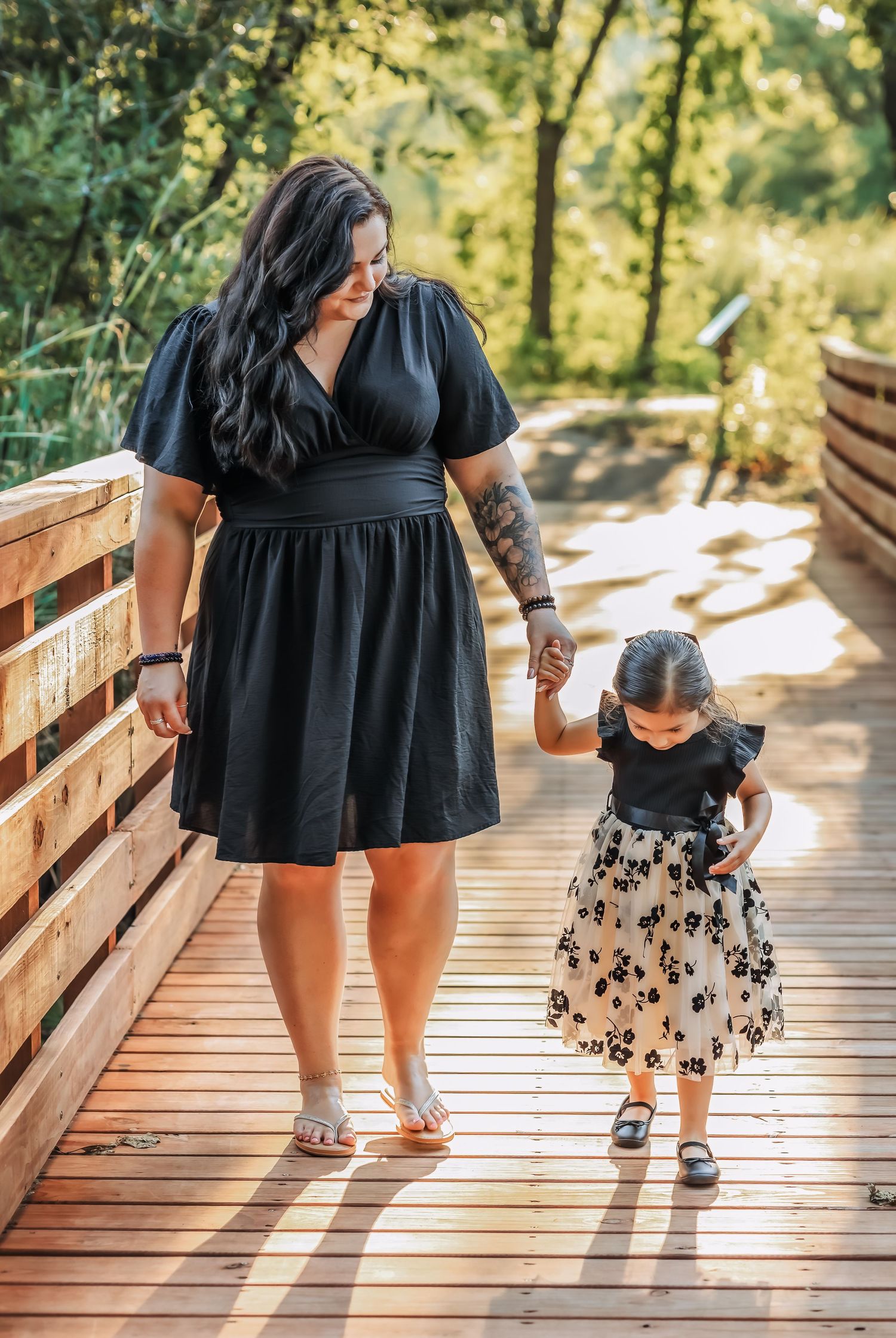Mother and daughter walking across a bridge