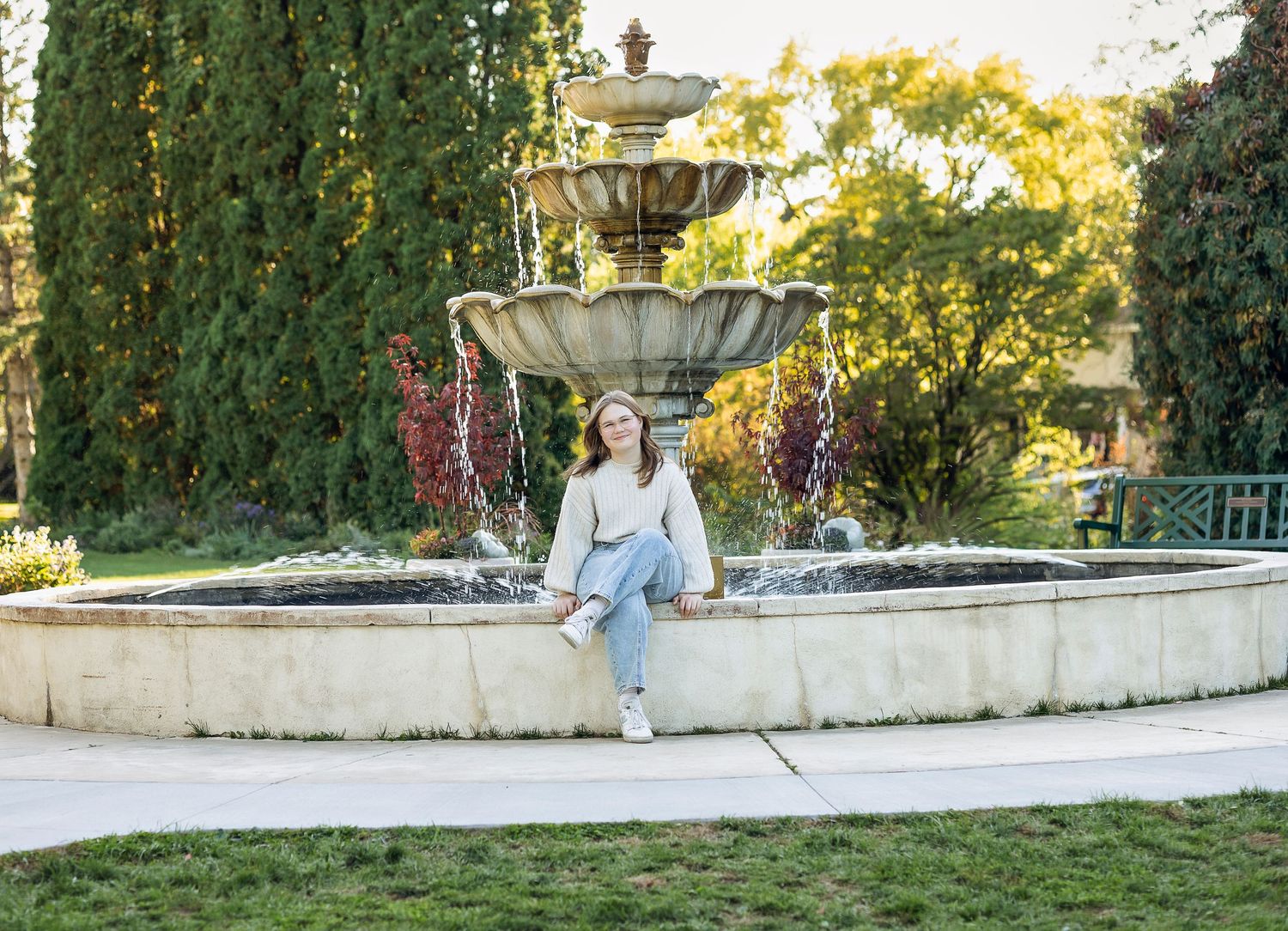 Girl sitting next to the water fountain smiling