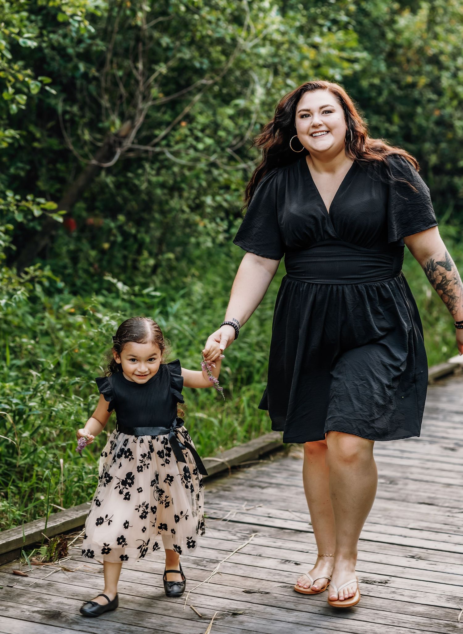 Mother looking at the camera while holding daughters hand