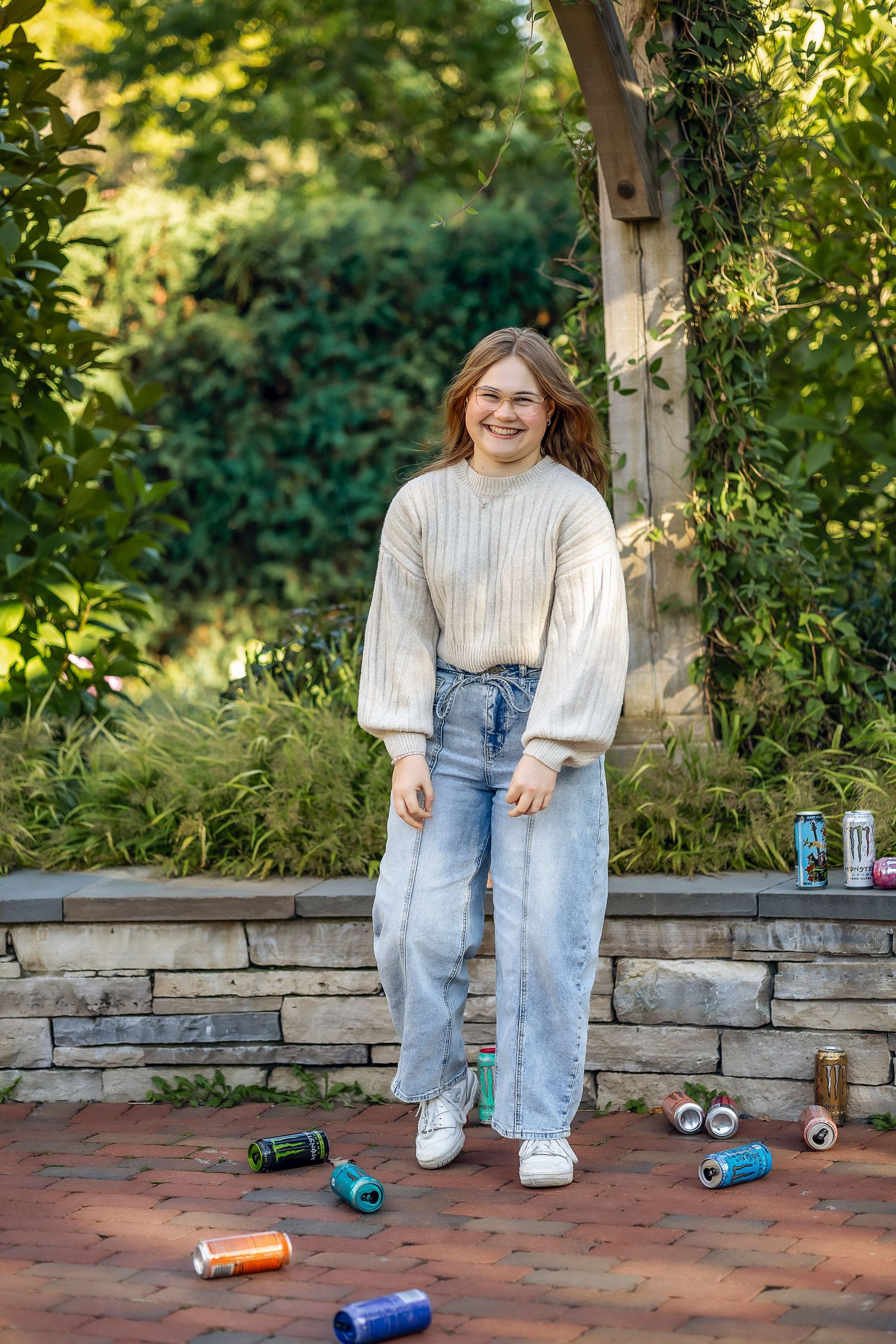 Girl smiling with Monster Energy drinks on the ground