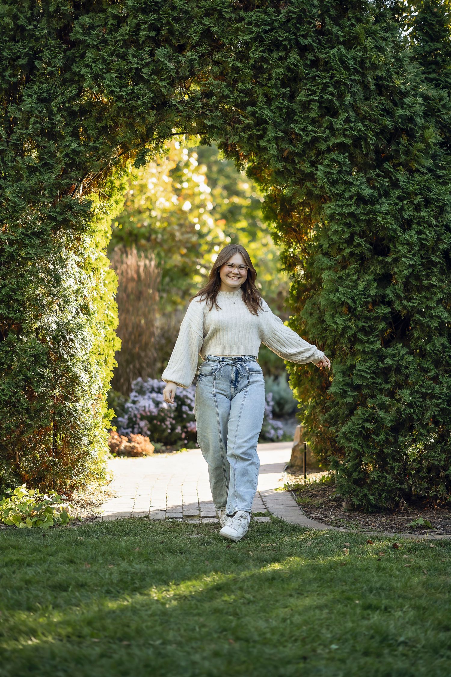 Senior girl walking through an arch