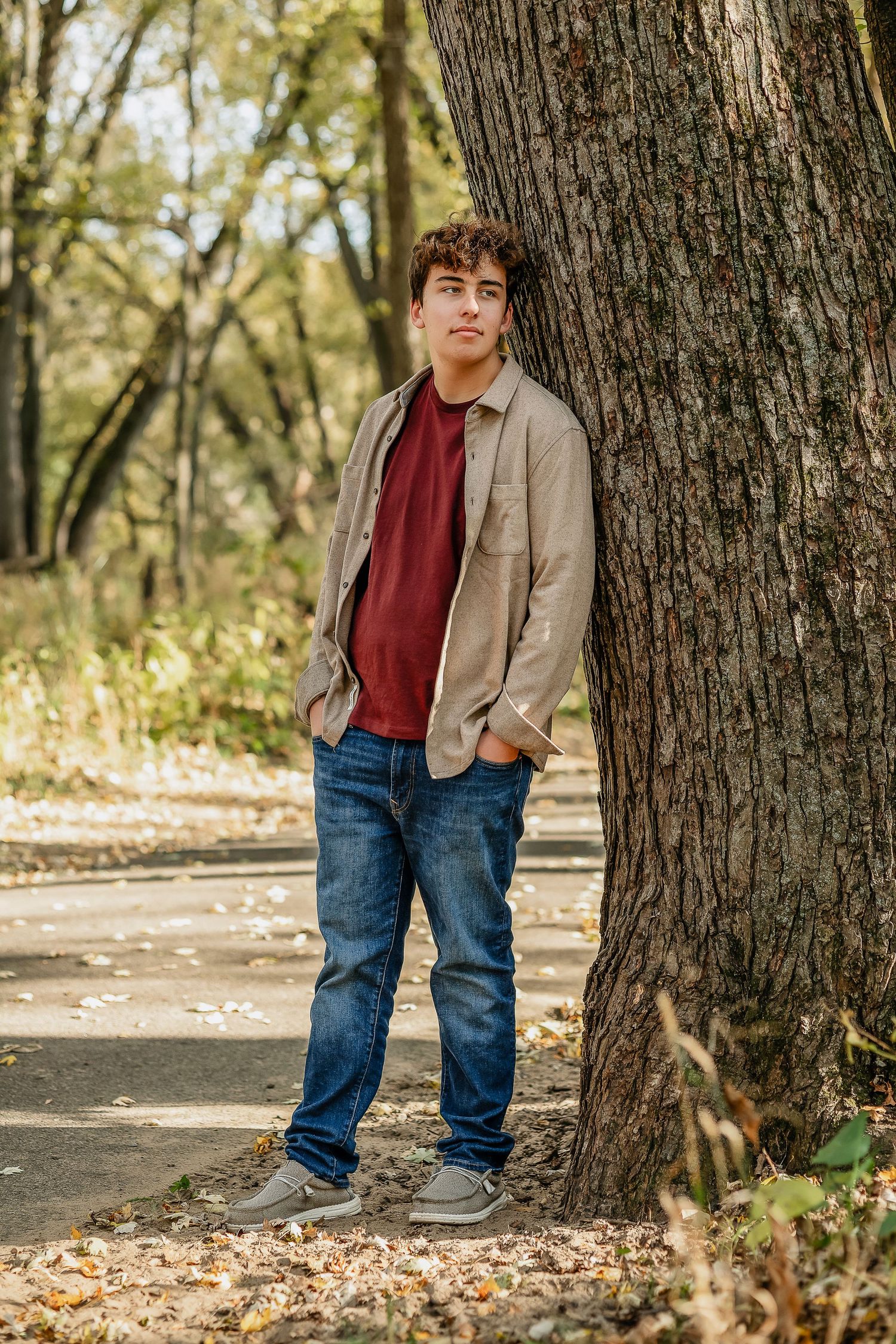 Boy wearing a red shirt next to a tree