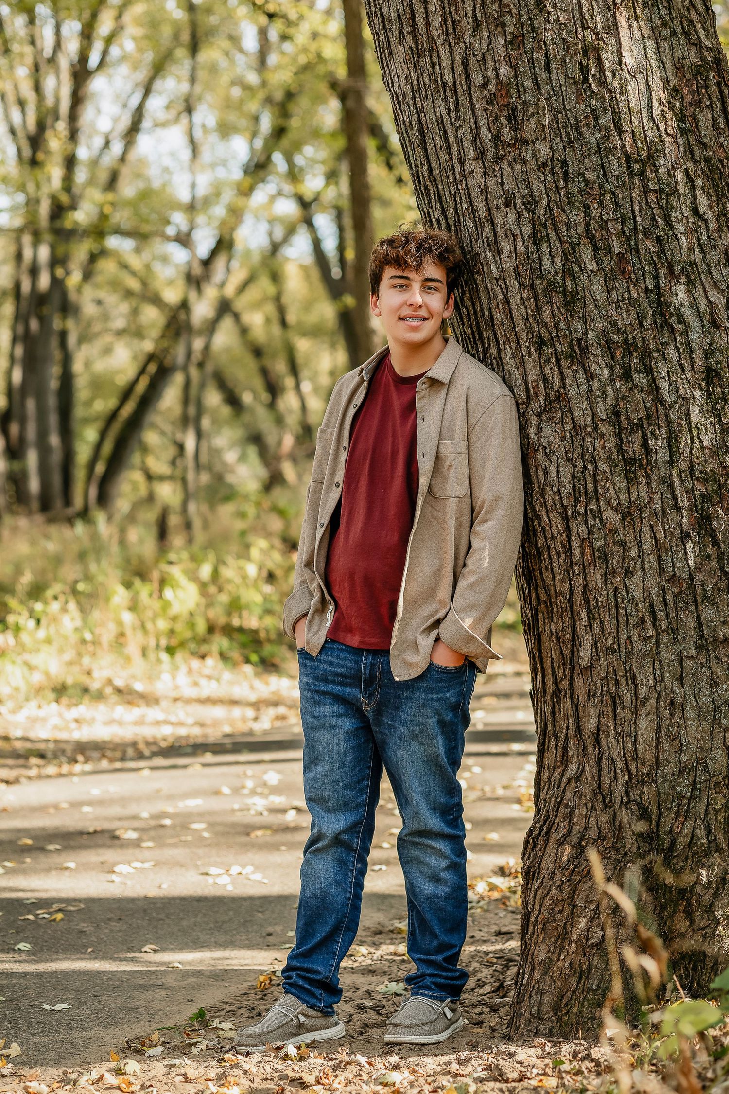 Boy leaning against a tree