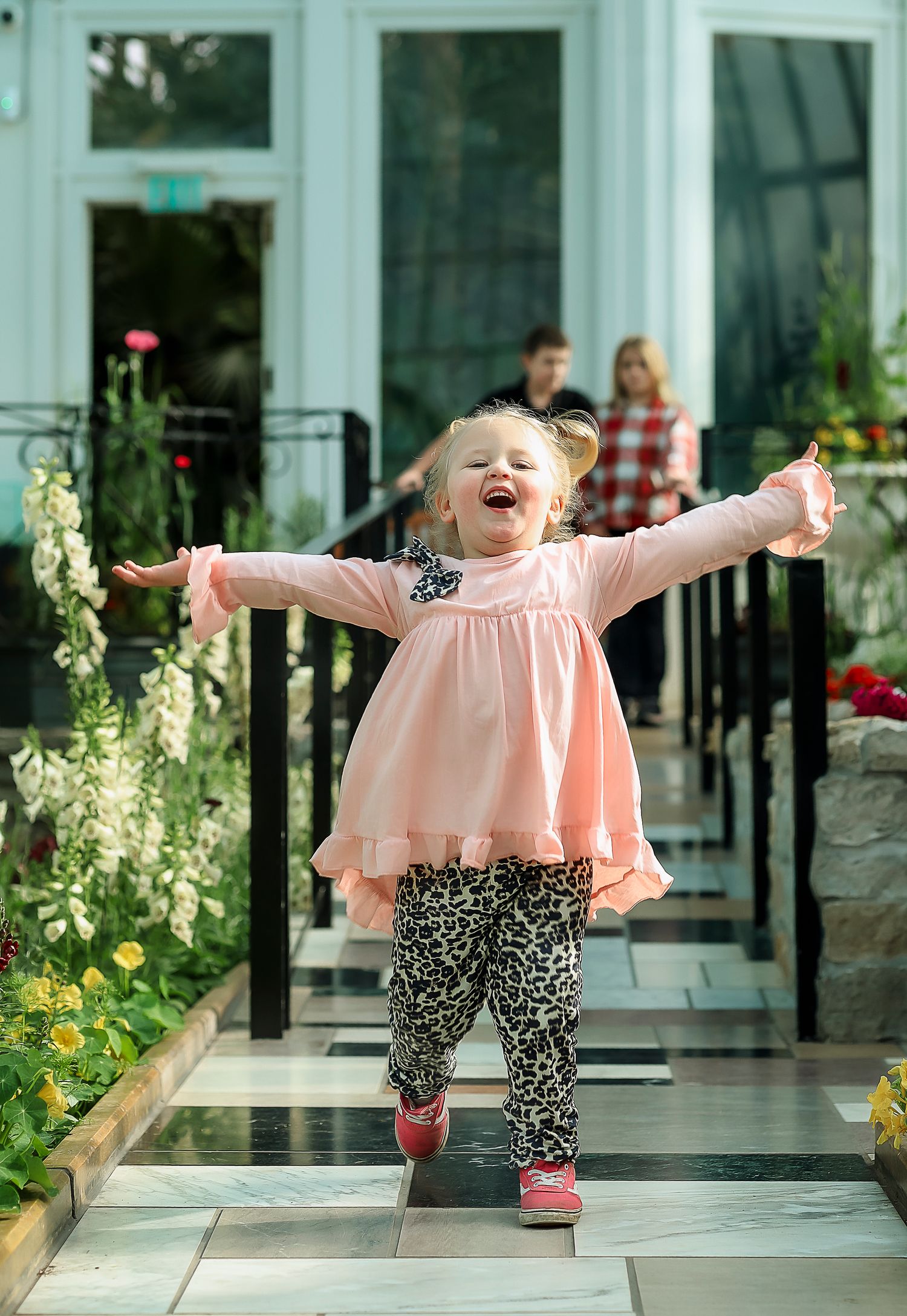 Little toddler very happy in a greenhouse