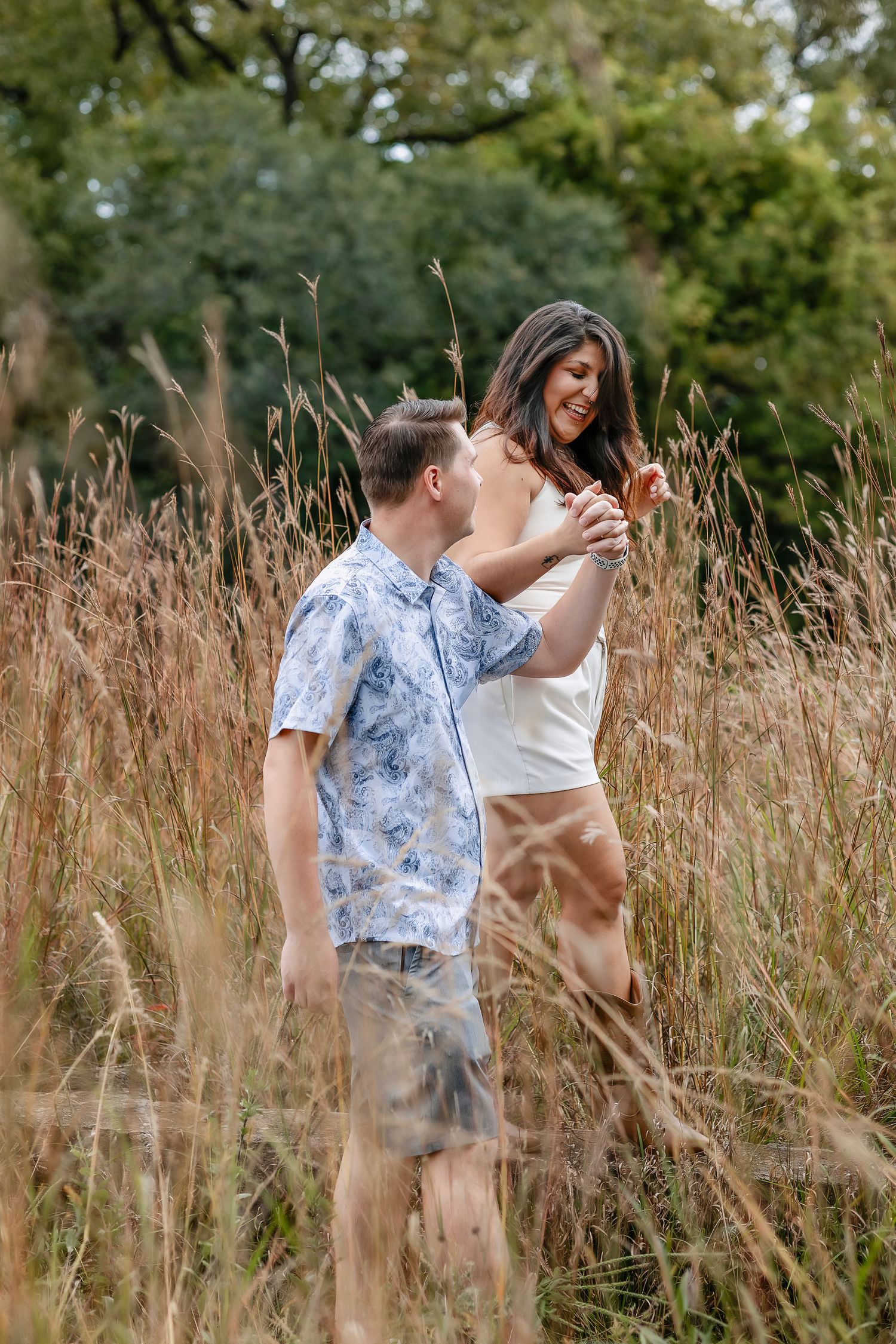 Couple walking in a prairie holding hands