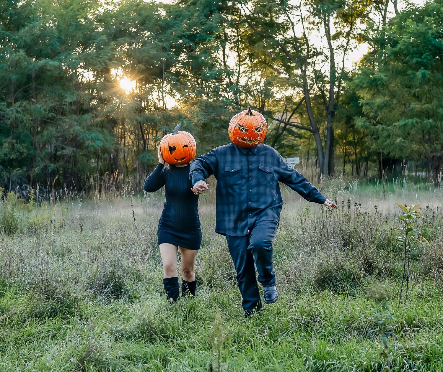 Pumpkin head lovers skipping across a meadow at sunset