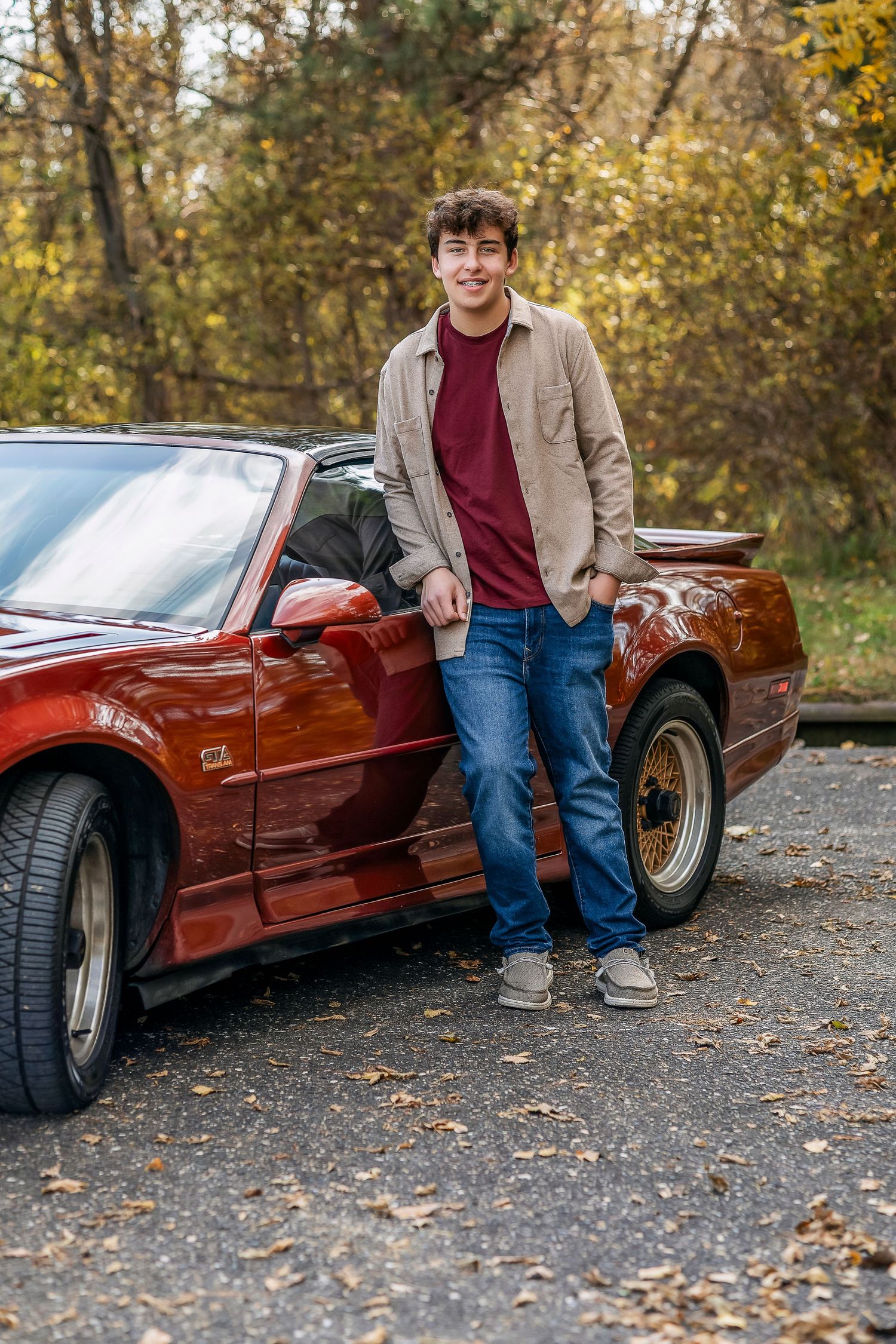 Young man leaning against a car