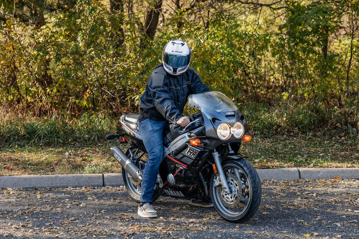 Side view of man sitting on motorcycle with white helmet on