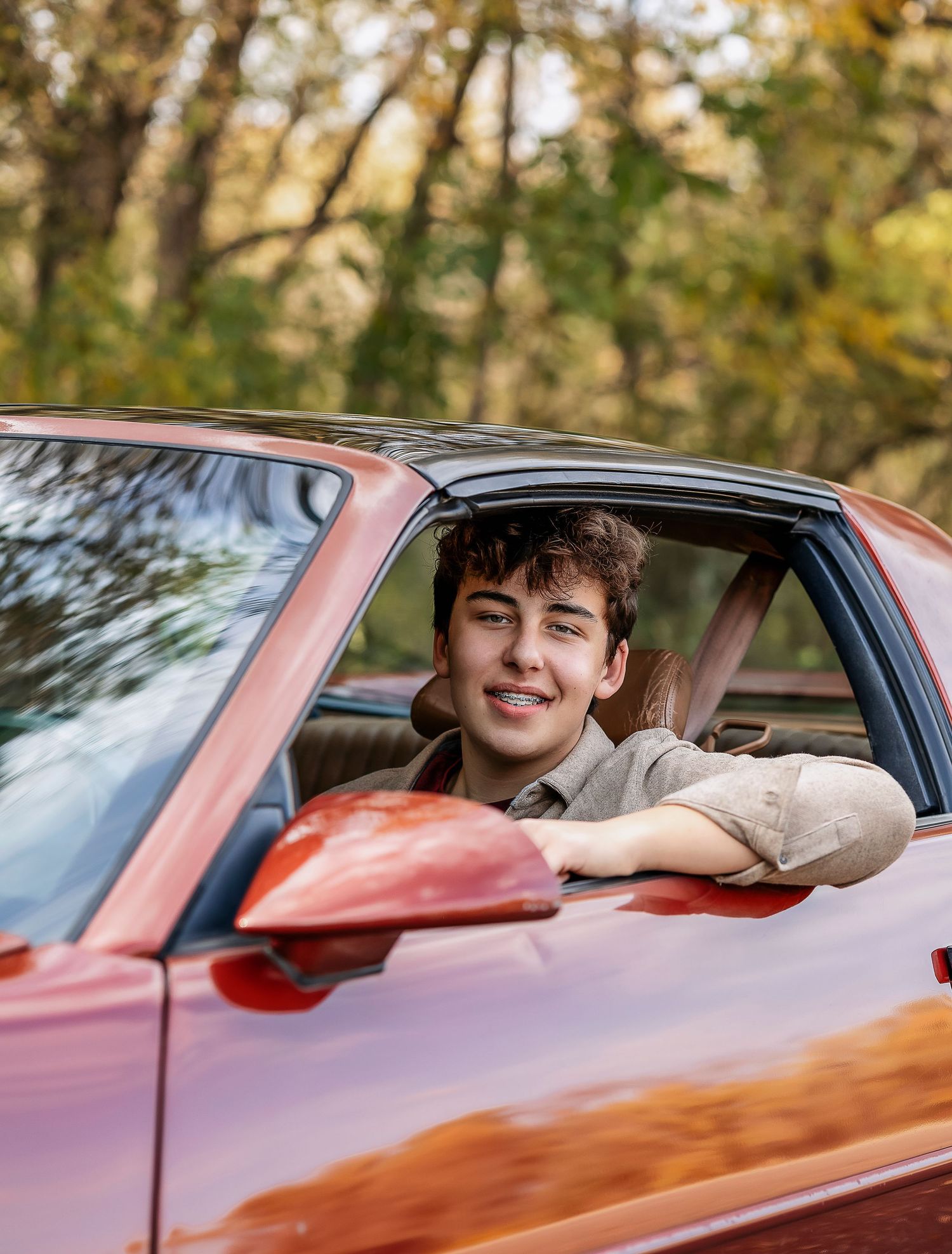 Man sitting in a red car smiling