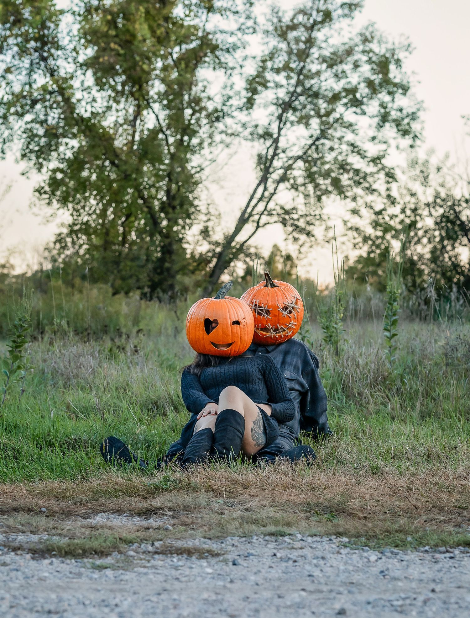 Pumpkin head couple laying in grass together
