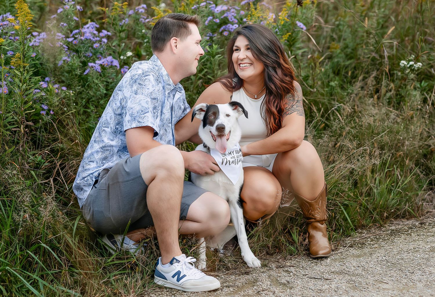 Couple smiling at each other with their dog