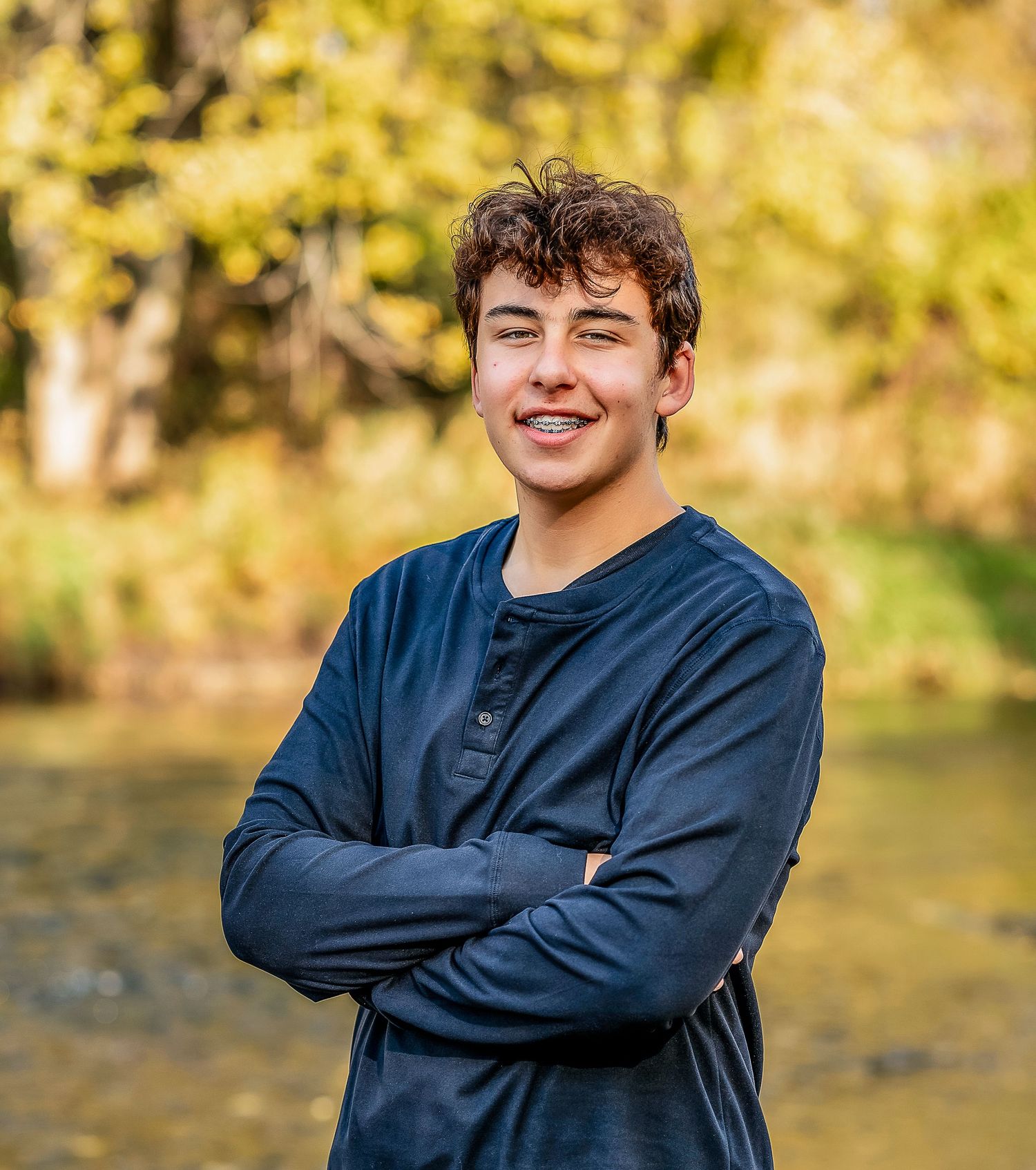 Young man with arms crossed smiling